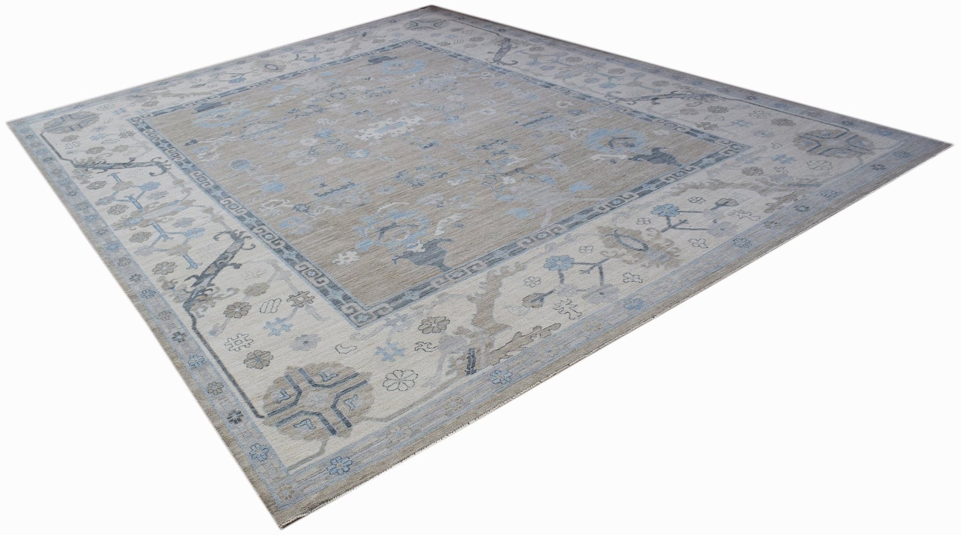 A handwoven transitional Oushak rug featuring a floral pattern in soft blue and beige tones.