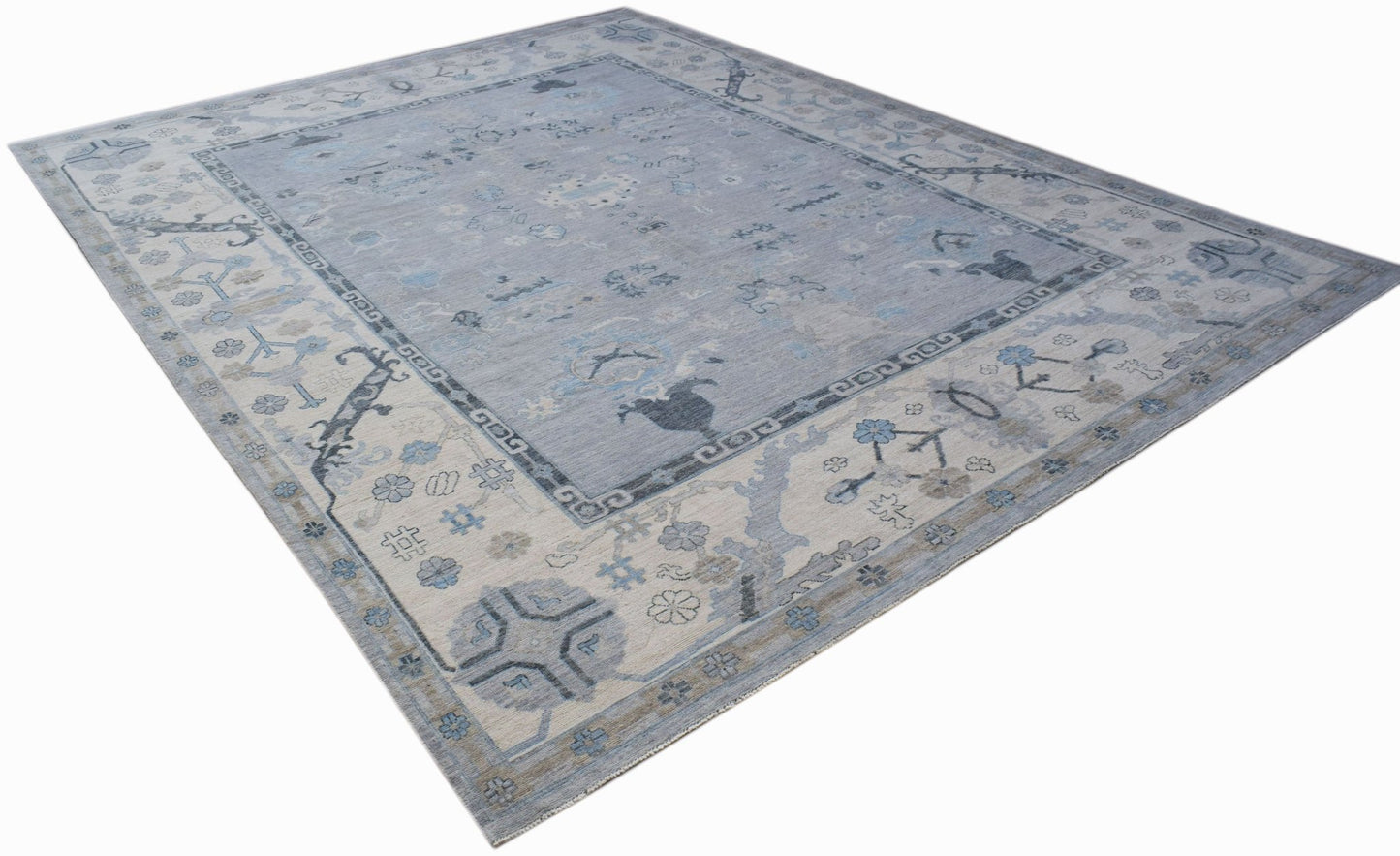 A handwoven transitional Oushak rug featuring a floral pattern in shades of blue and cream.