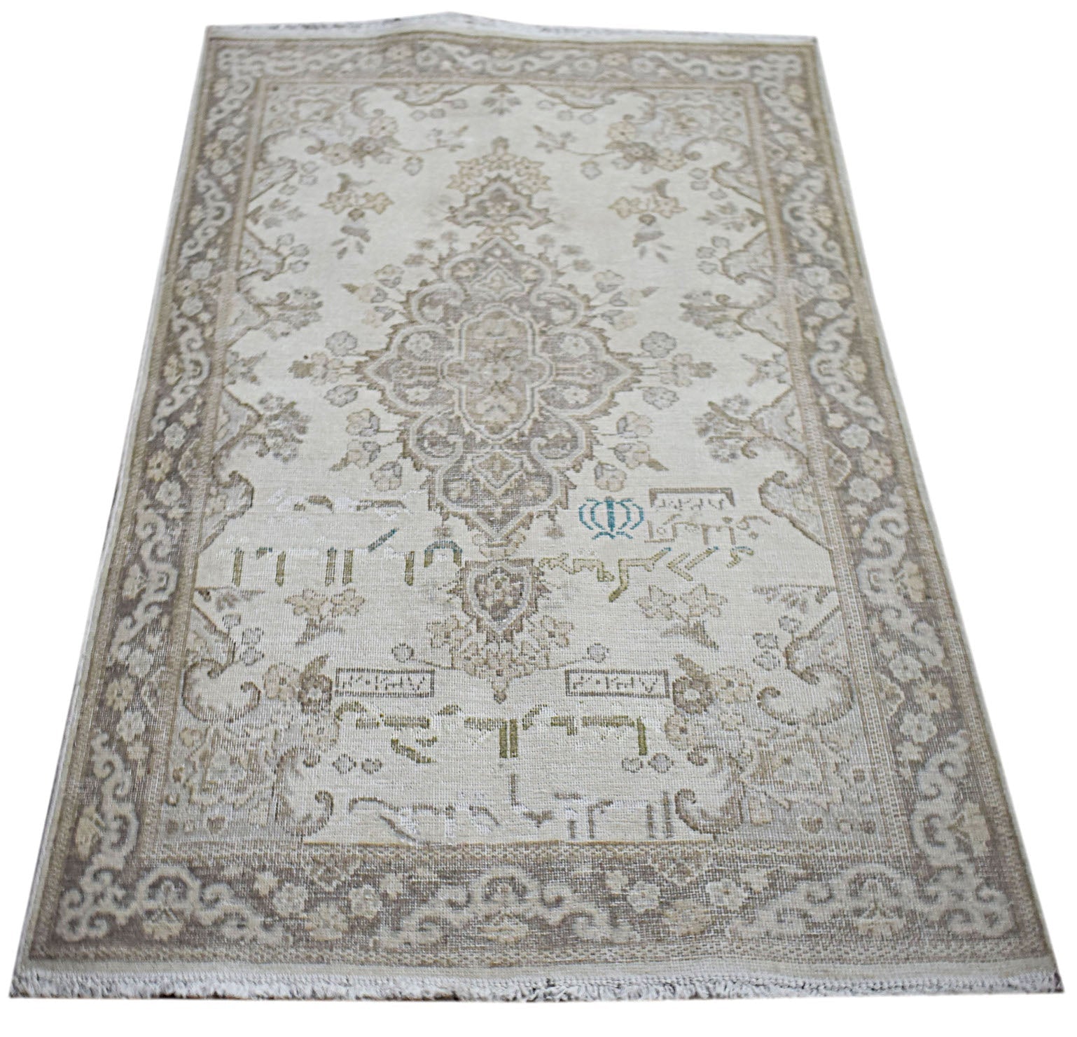 A vintage Persian Kerman rug featuring a central medallion and intricate floral patterns in beige.