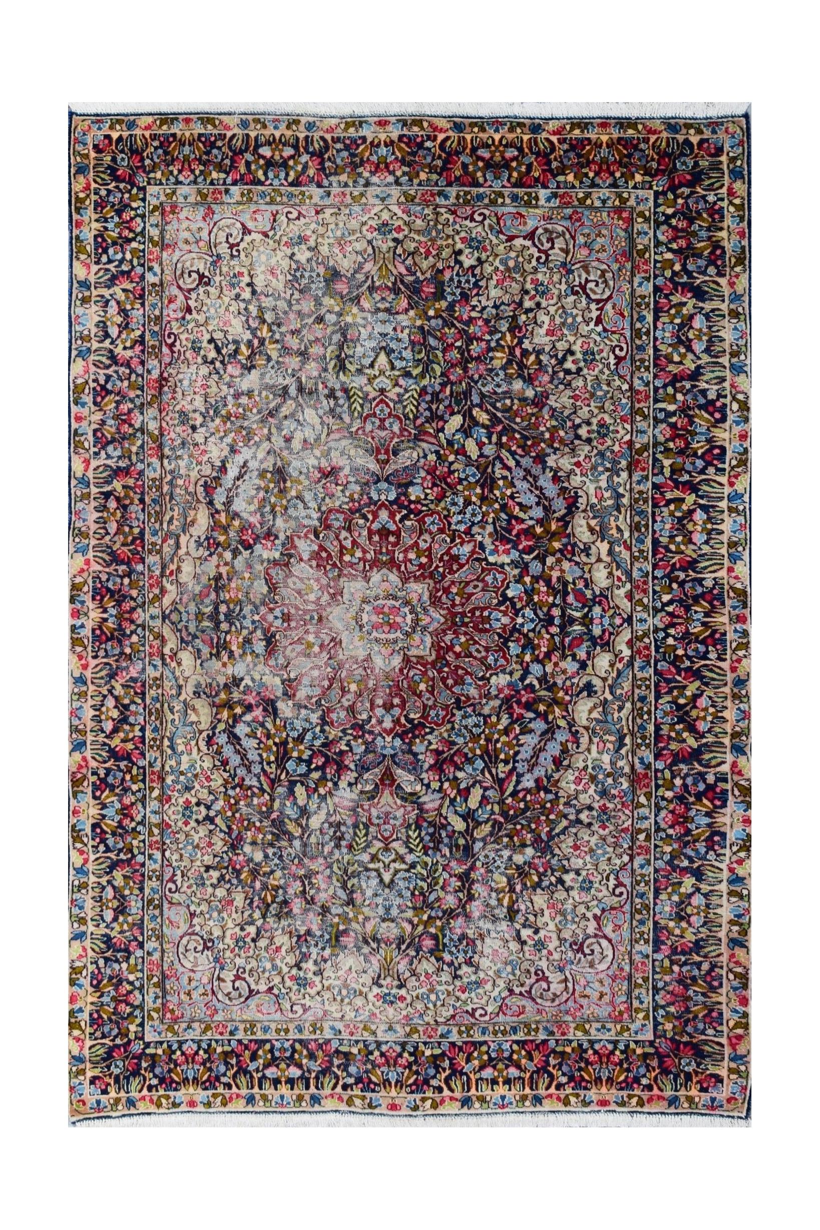 A vintage Persian Kerman rug featuring an intricate floral medallion design in soft, muted tones.