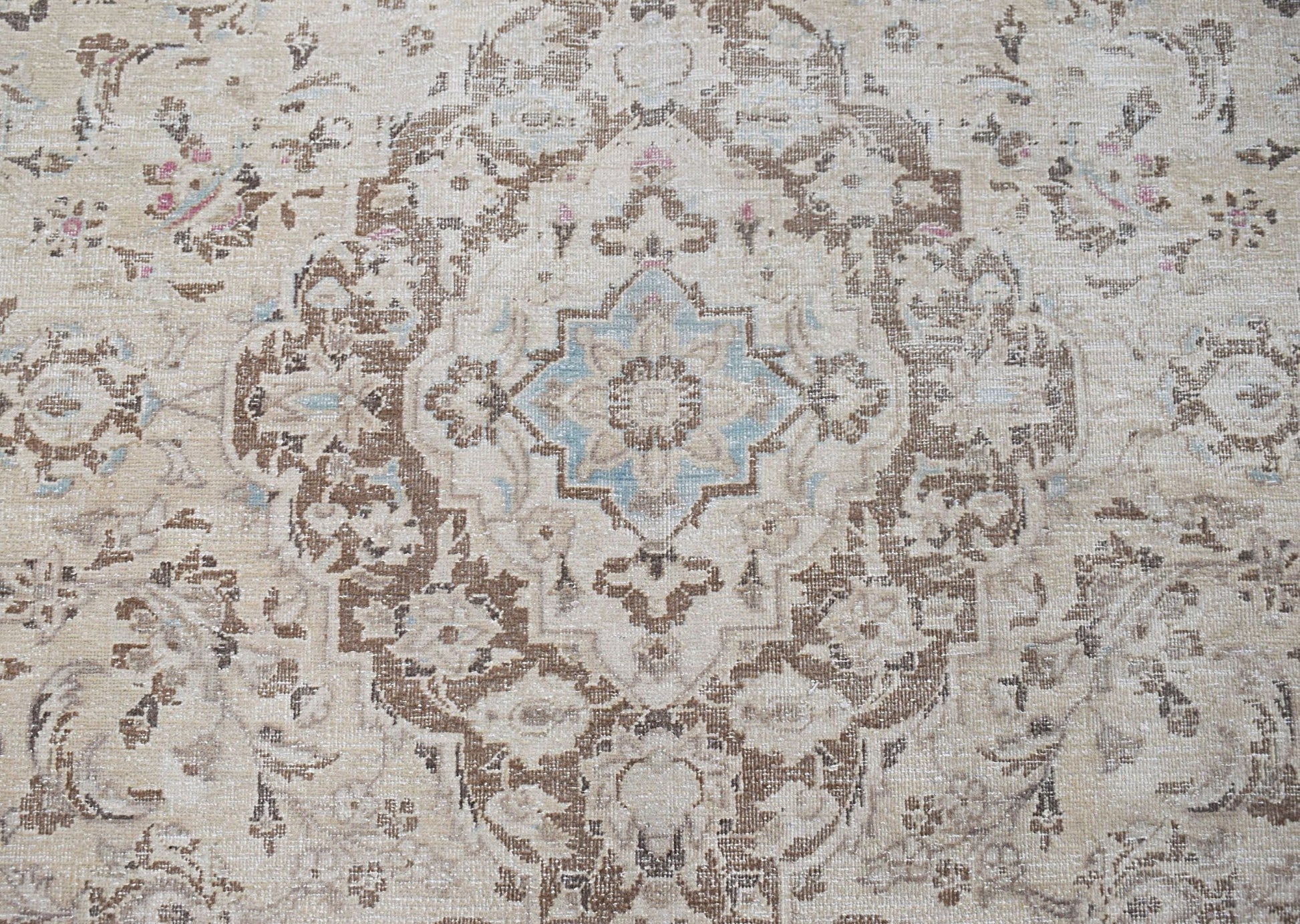A vintage Persian Kerman rug featuring a central medallion with intricate floral patterns.