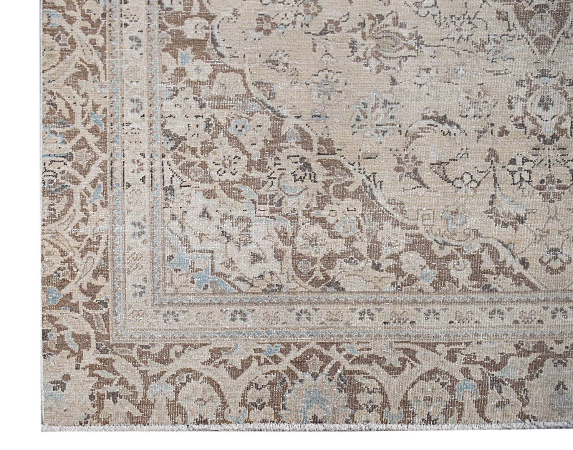 A vintage Persian Kerman rug featuring an intricate floral medallion design in beige and blue tones.