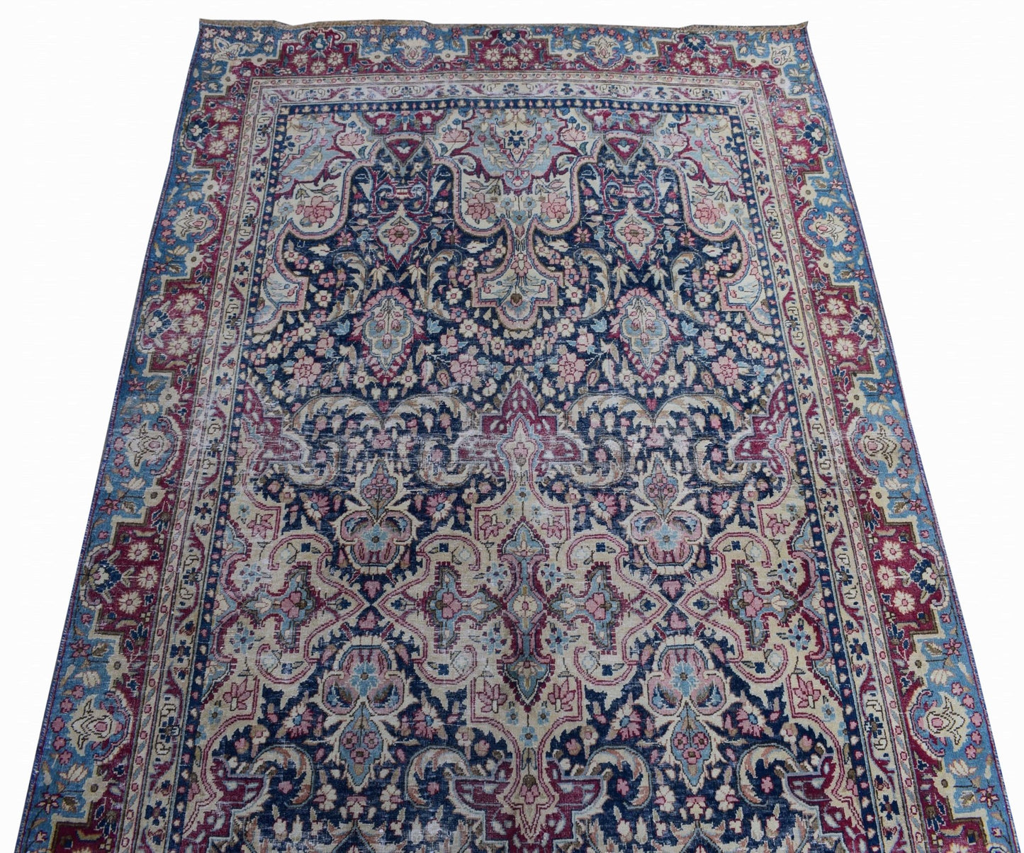 A vintage Persian Kerman rug featuring an intricate floral medallion design in blue and pink tones.