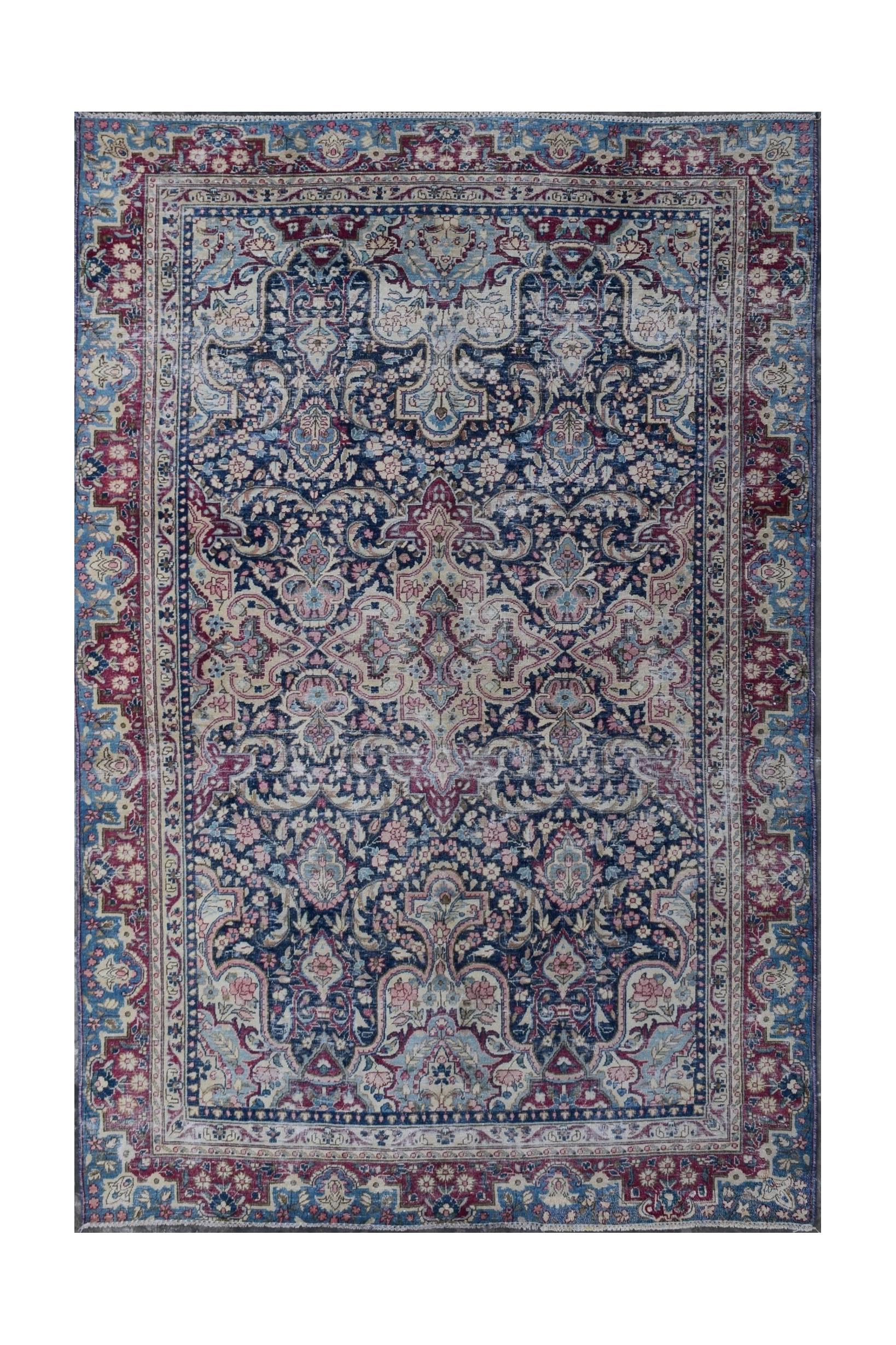 A vintage Persian Kerman rug featuring an intricate floral medallion design in blue and red tones.