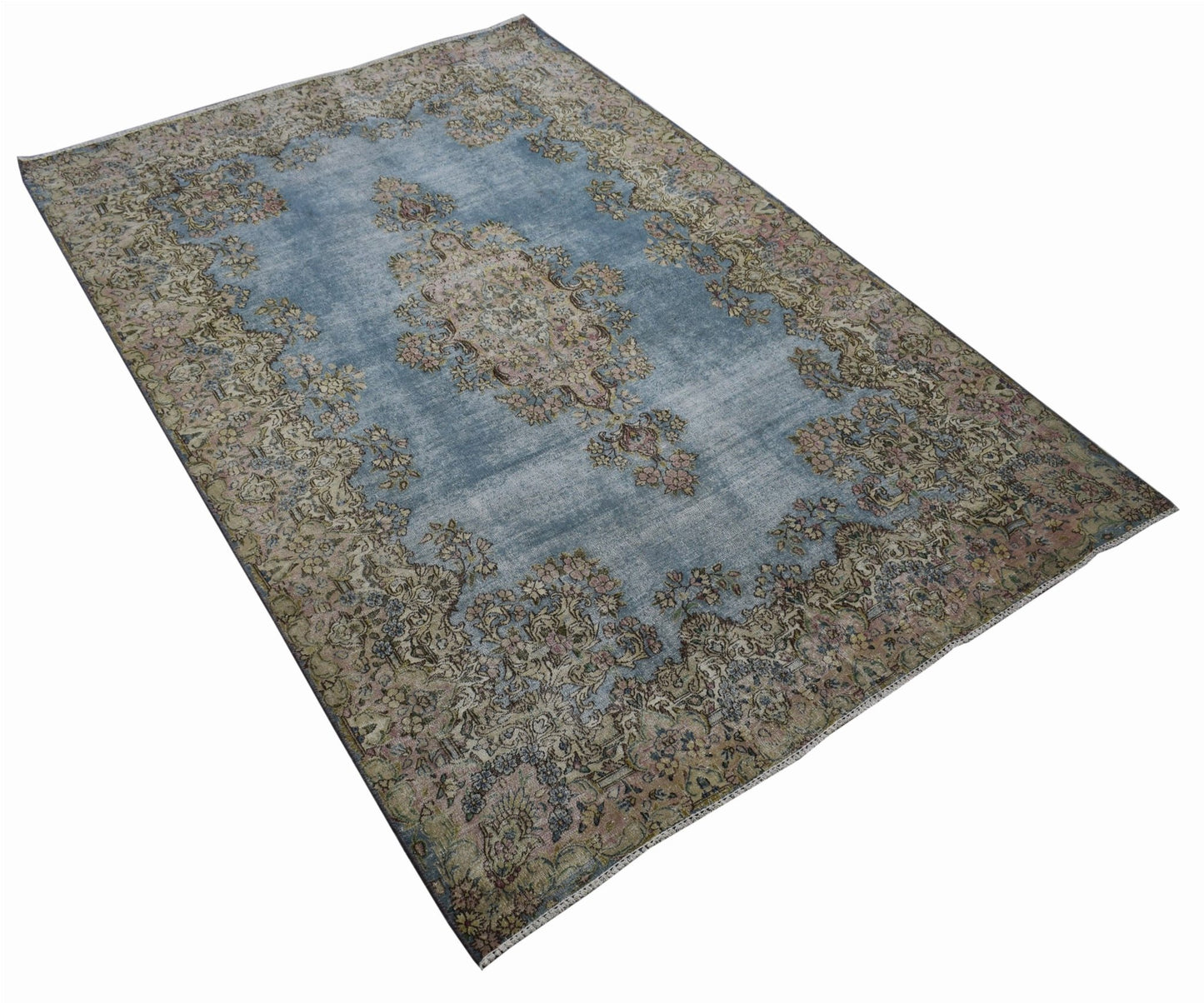 A vintage Persian Kerman rug featuring a central medallion and intricate floral patterns in blue.