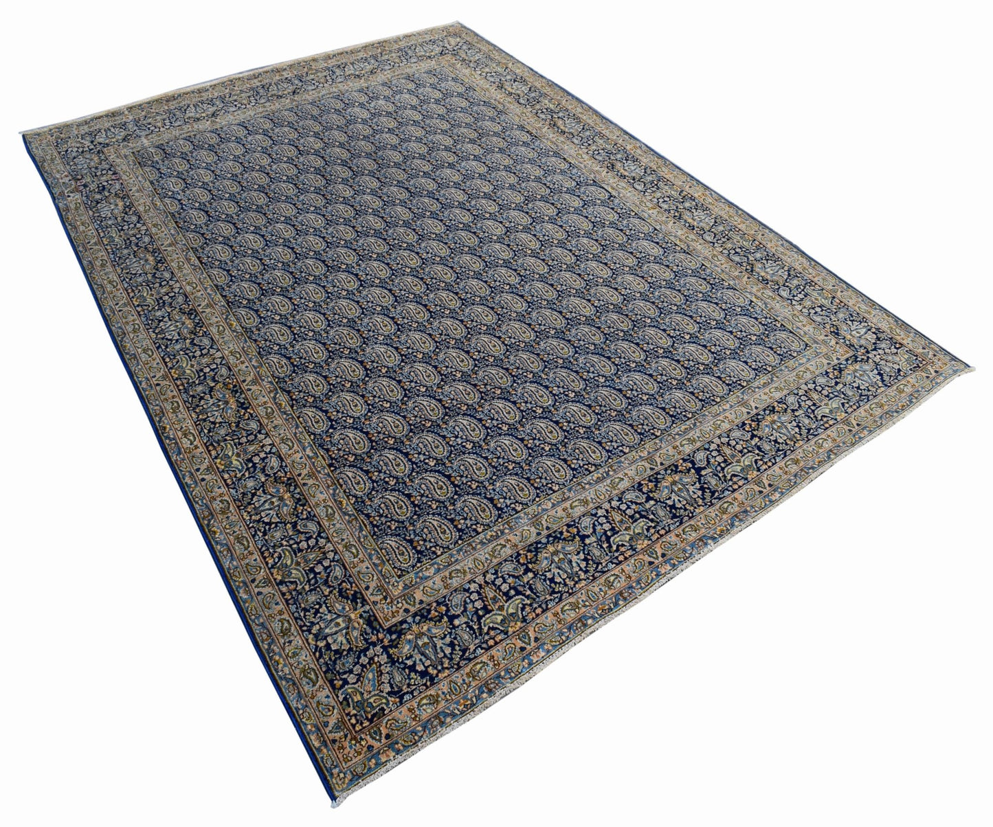 A vintage Persian Kerman rug featuring an all-over blue paisley pattern and a detailed floral border.