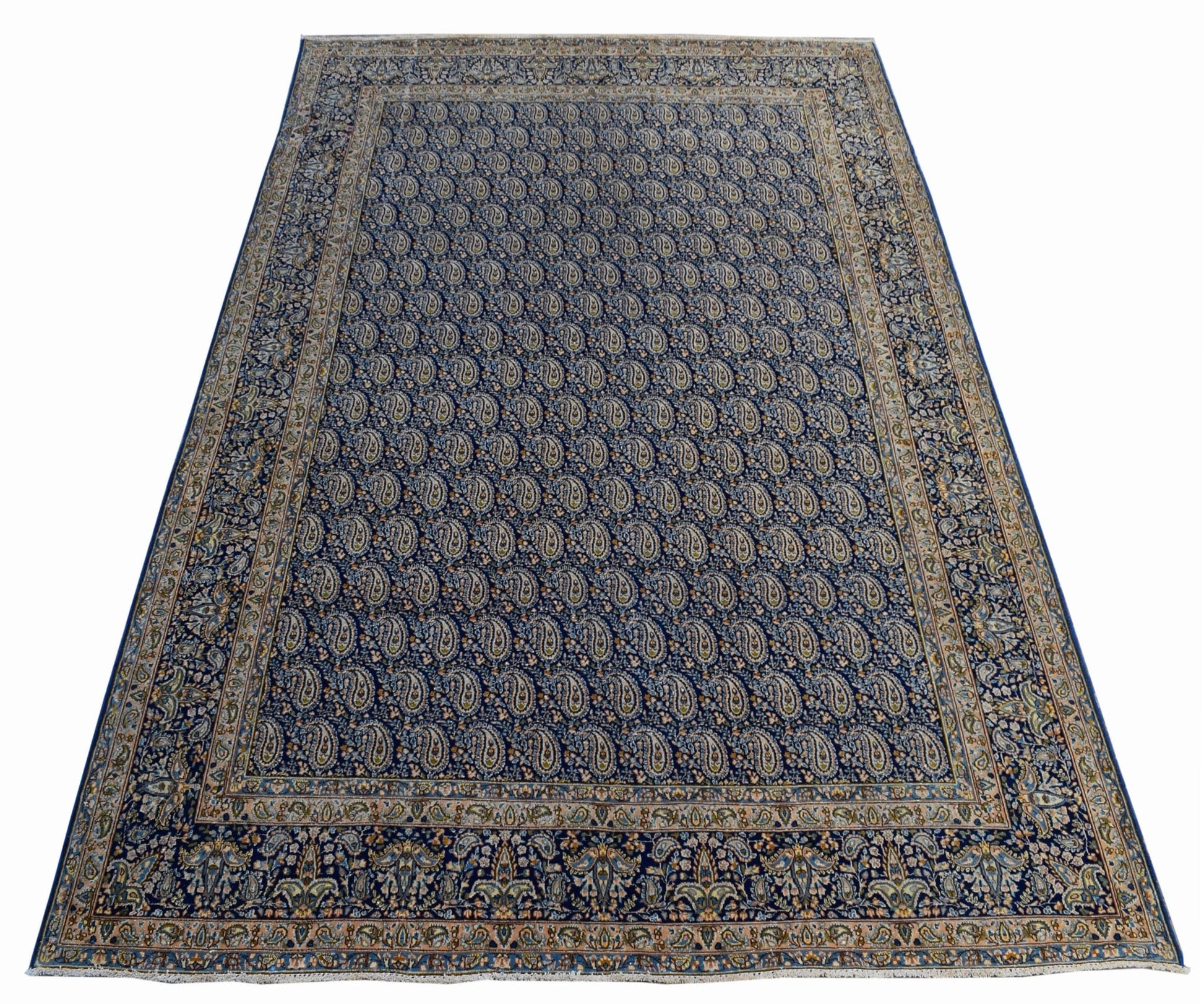 A vintage Persian Kerman rug featuring an intricate blue field with a repeating paisley pattern.