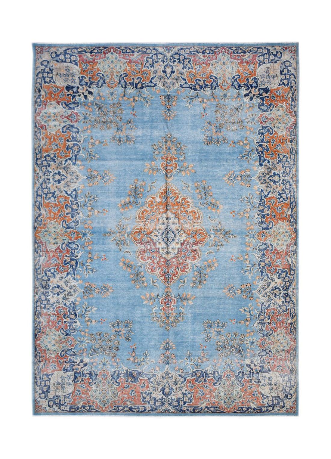 A vintage Persian Kerman rug featuring a central medallion and floral motifs in blue and orange.