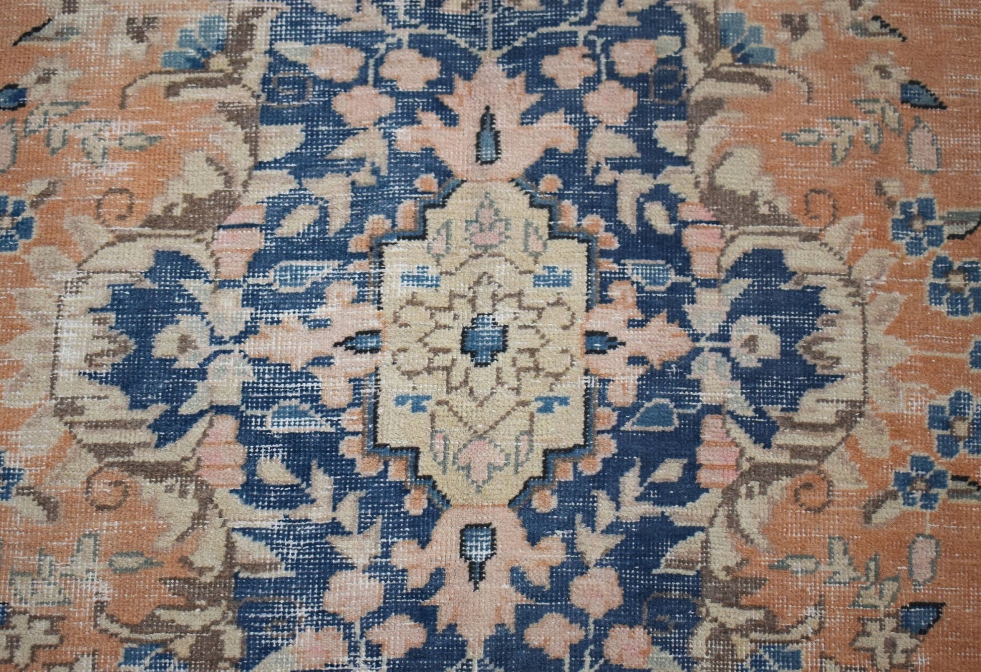 A vintage Persian Kerman rug featuring a central medallion with intricate floral patterns.