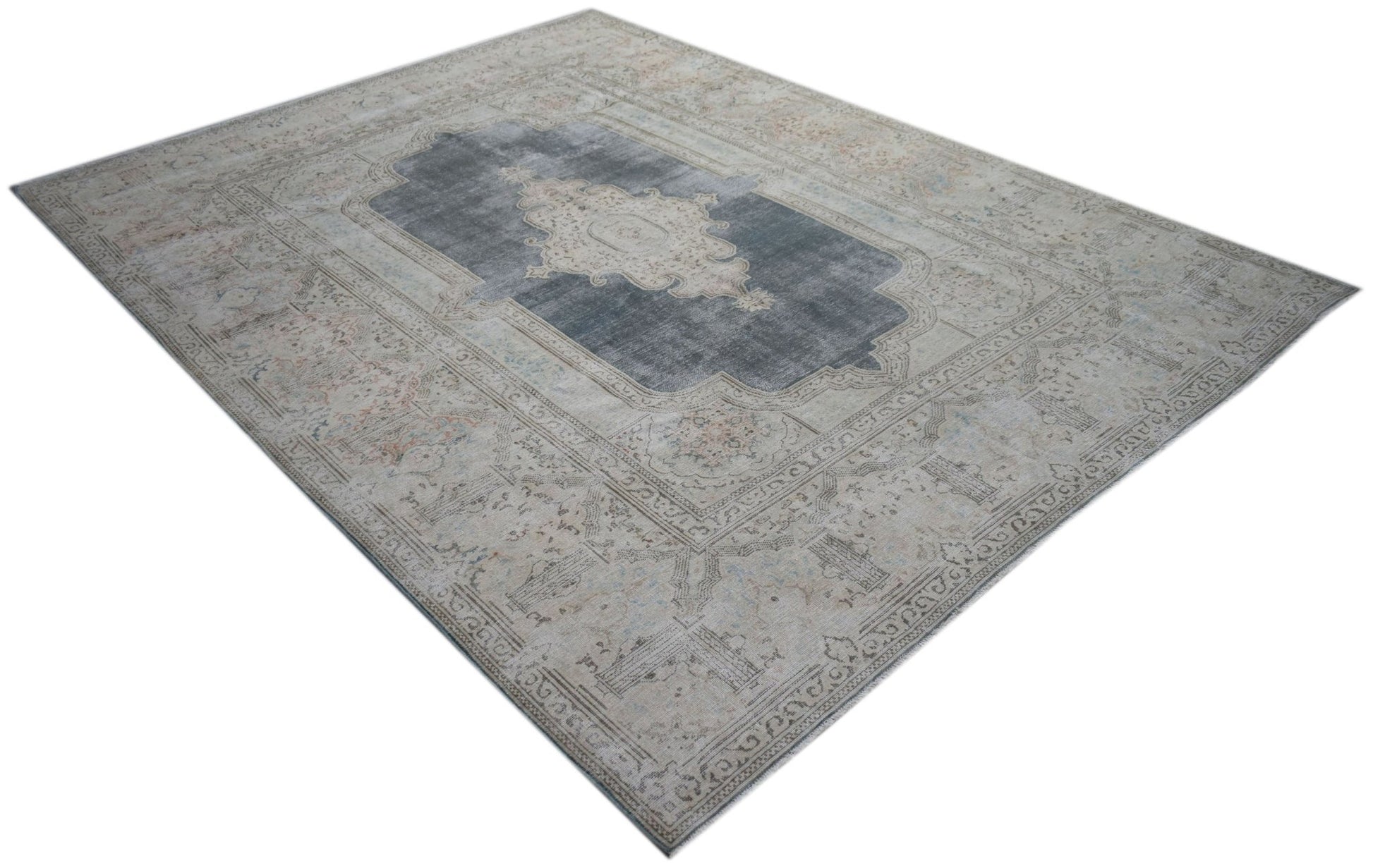 A vintage Persian Kerman rug featuring a central medallion on a grey field with floral borders.