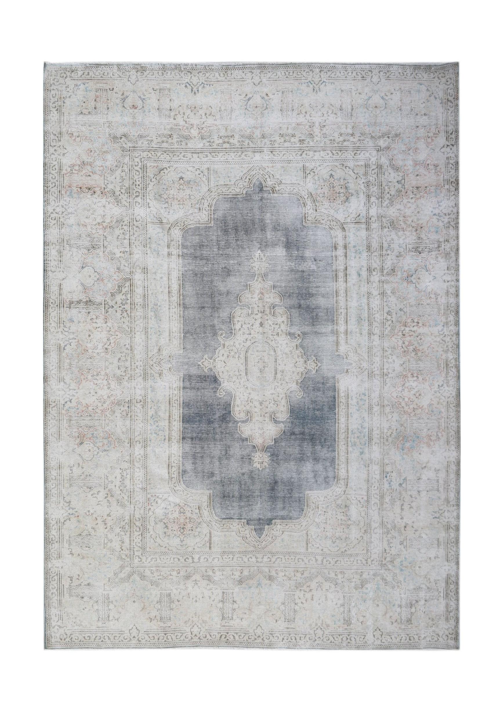 A vintage Persian Kerman rug featuring a central medallion on a grey field with floral borders.