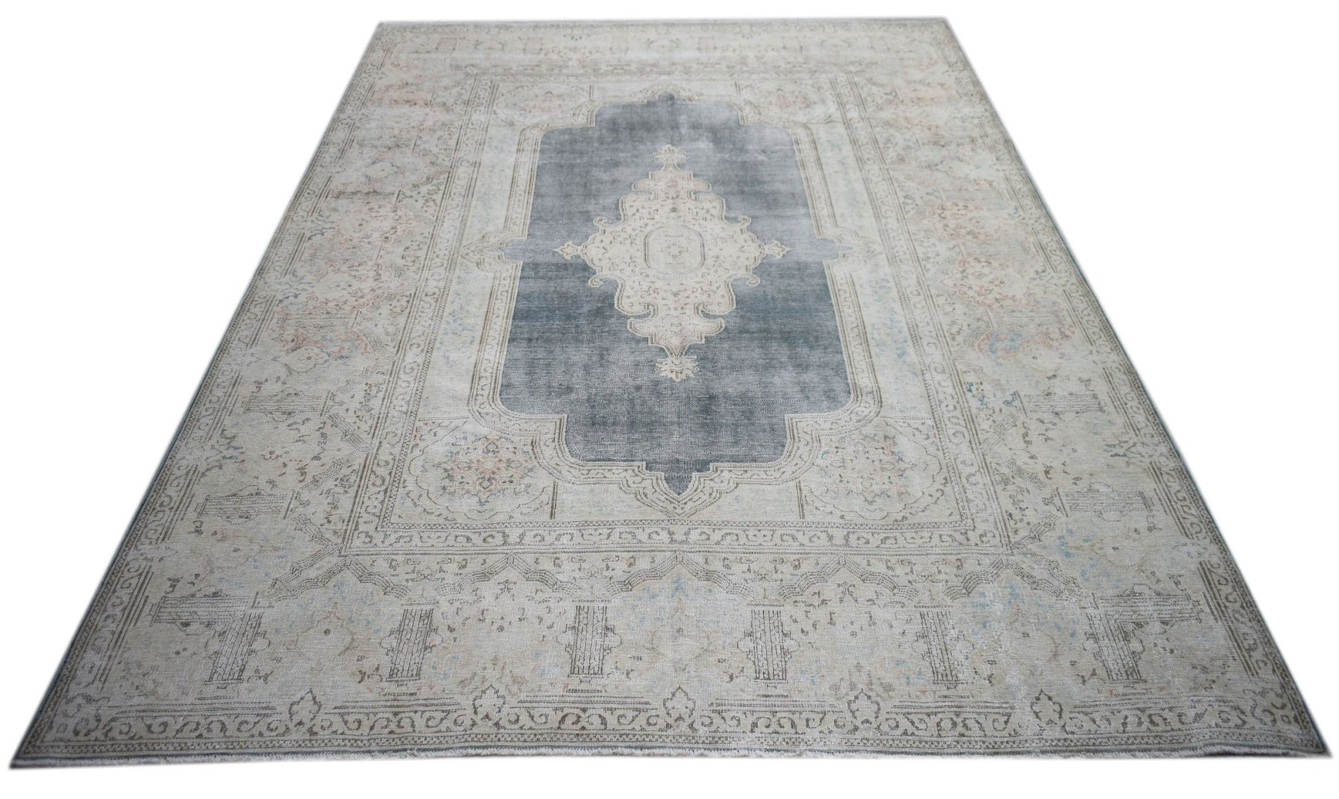 A vintage Persian Kerman rug featuring a central medallion on a grey field with floral motifs.