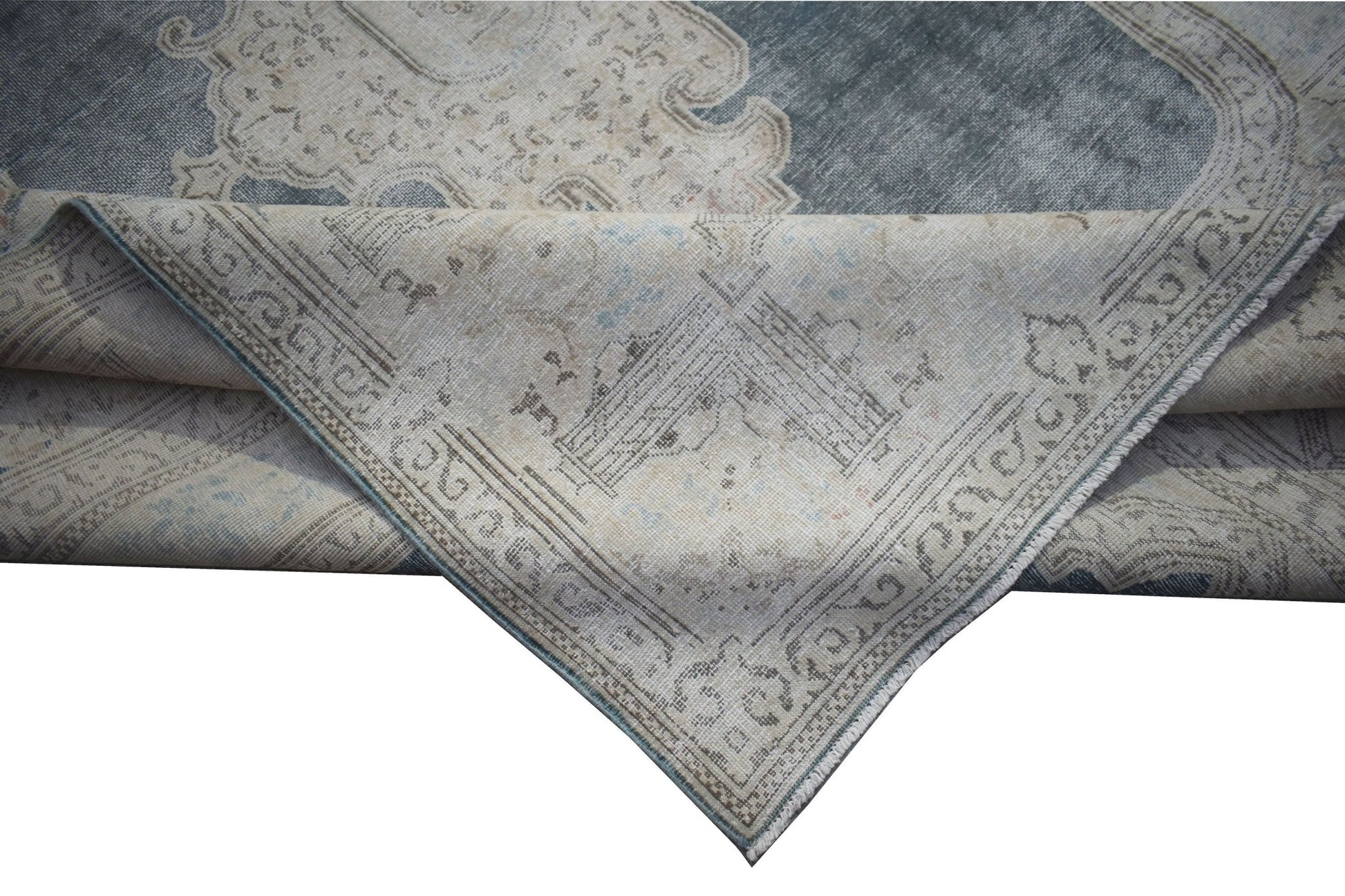 A vintage Persian Kerman rug featuring a blue and beige floral medallion design.