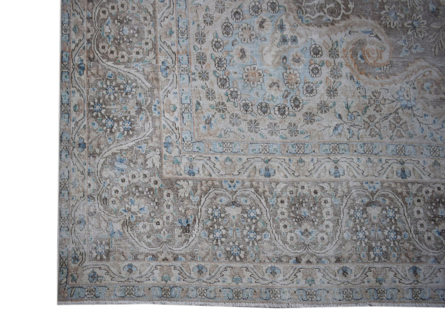 A vintage Persian Kerman rug featuring an intricate floral medallion design in muted earth tones.