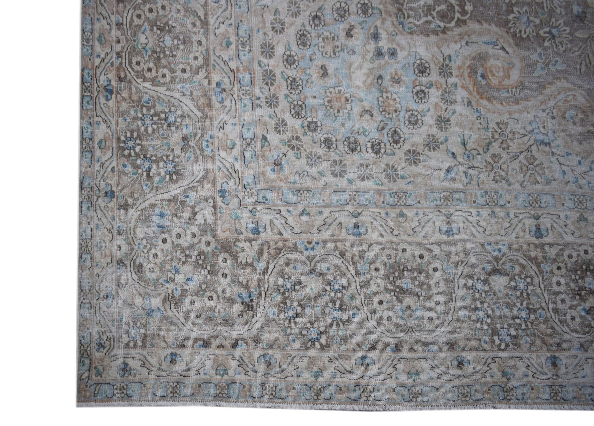 A vintage Persian Kerman rug featuring an intricate floral medallion design in muted earth tones.