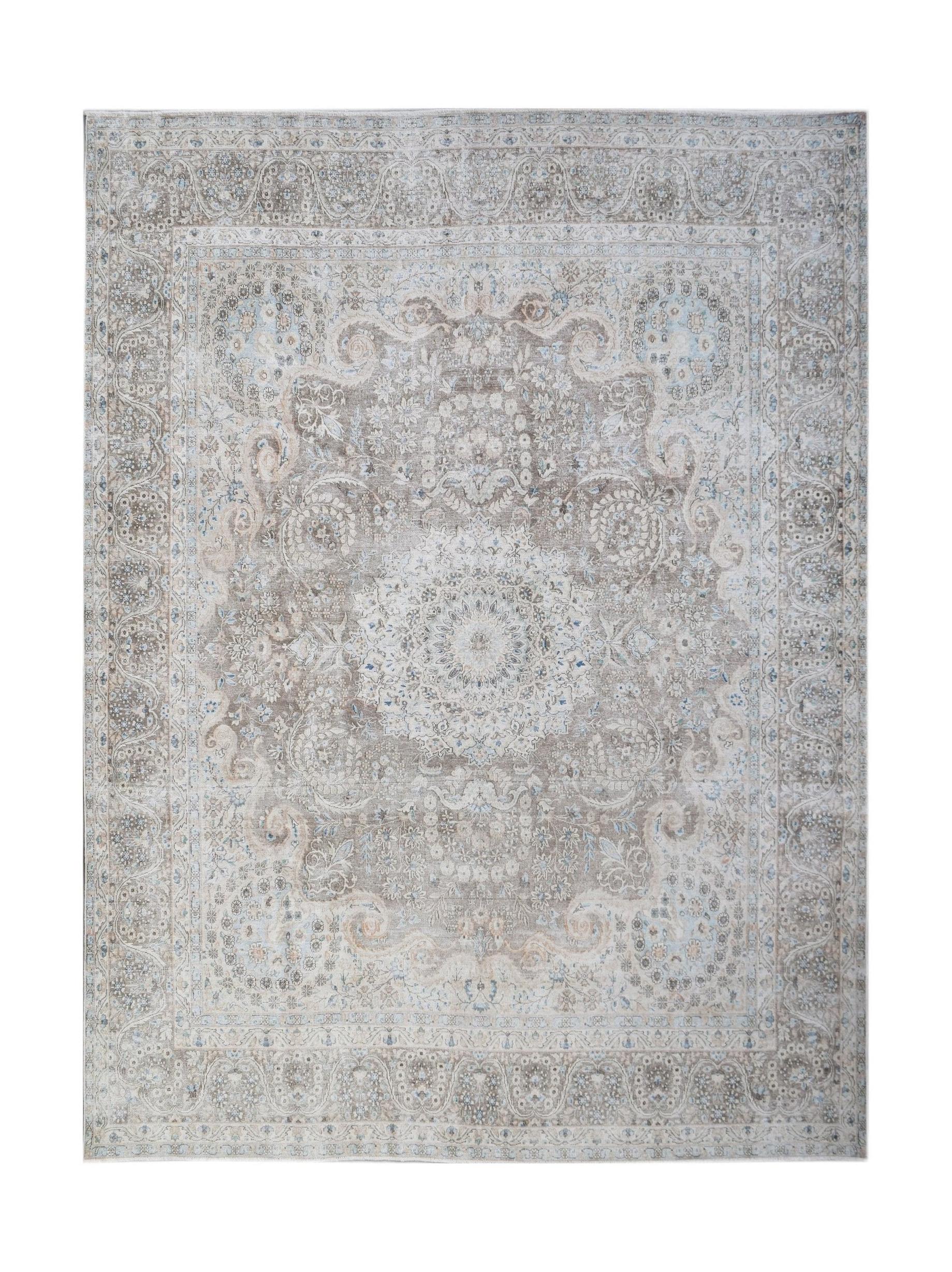 A vintage Persian Kerman rug featuring an intricate floral medallion in soft beige and blue tones.