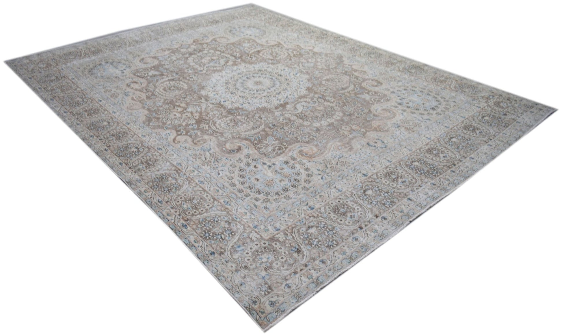 A vintage Persian Kerman rug featuring an intricate floral medallion design in soft neutral tones.