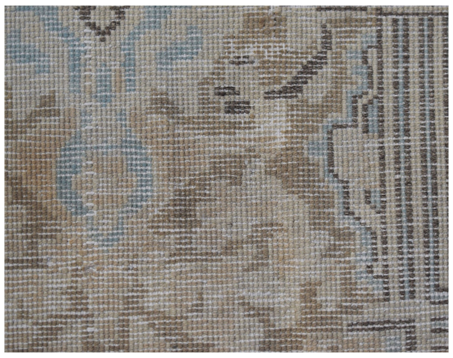 A close-up view of a vintage Persian Kerman rug featuring intricate floral patterns in soft tones.