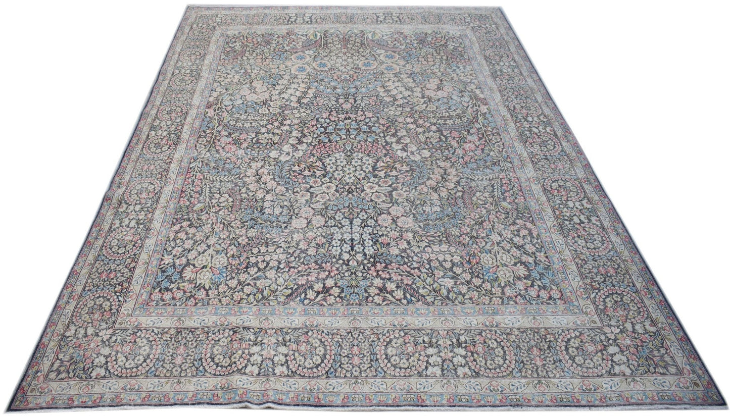 A vintage Persian Kerman rug featuring an intricate floral pattern and a central medallion.