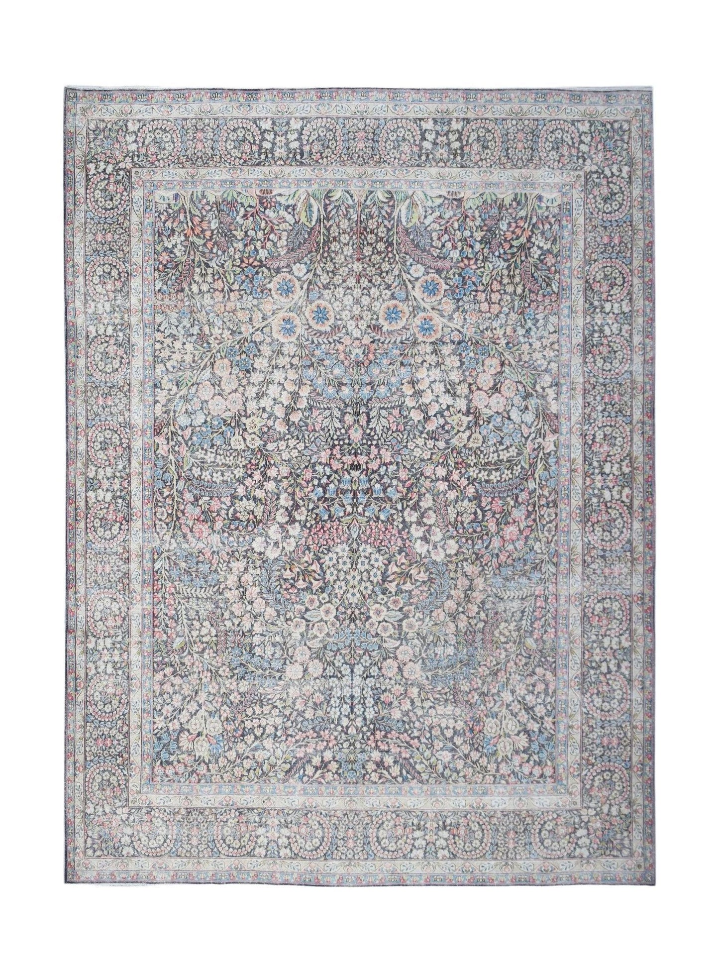A vintage Persian Kerman rug featuring an intricate floral pattern in soft, muted tones.