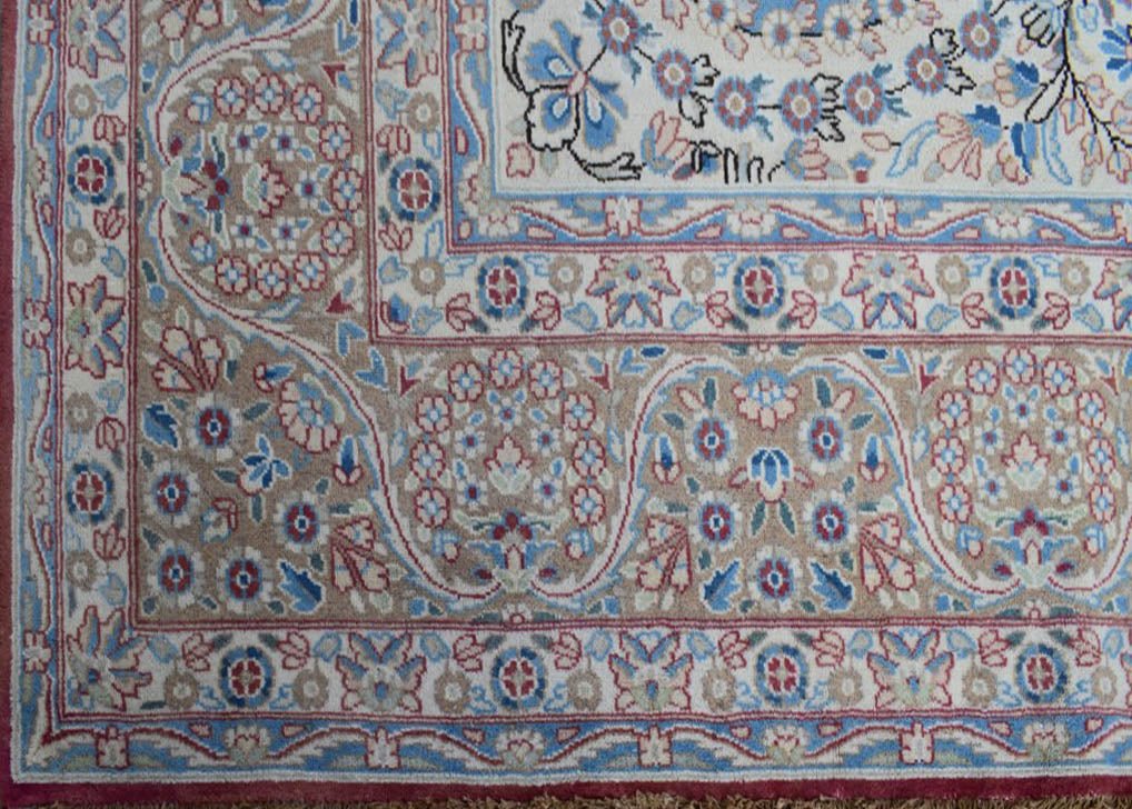 A vintage Persian Kerman rug featuring intricate floral patterns and a classic medallion design.