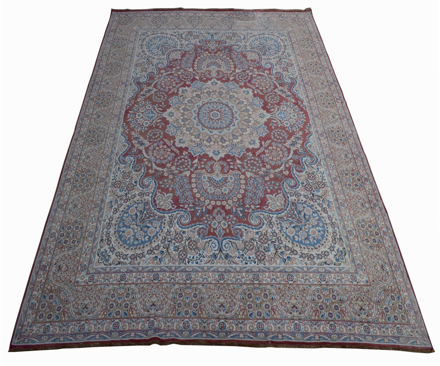 A vintage Persian Kerman rug featuring a central medallion and intricate floral patterns.