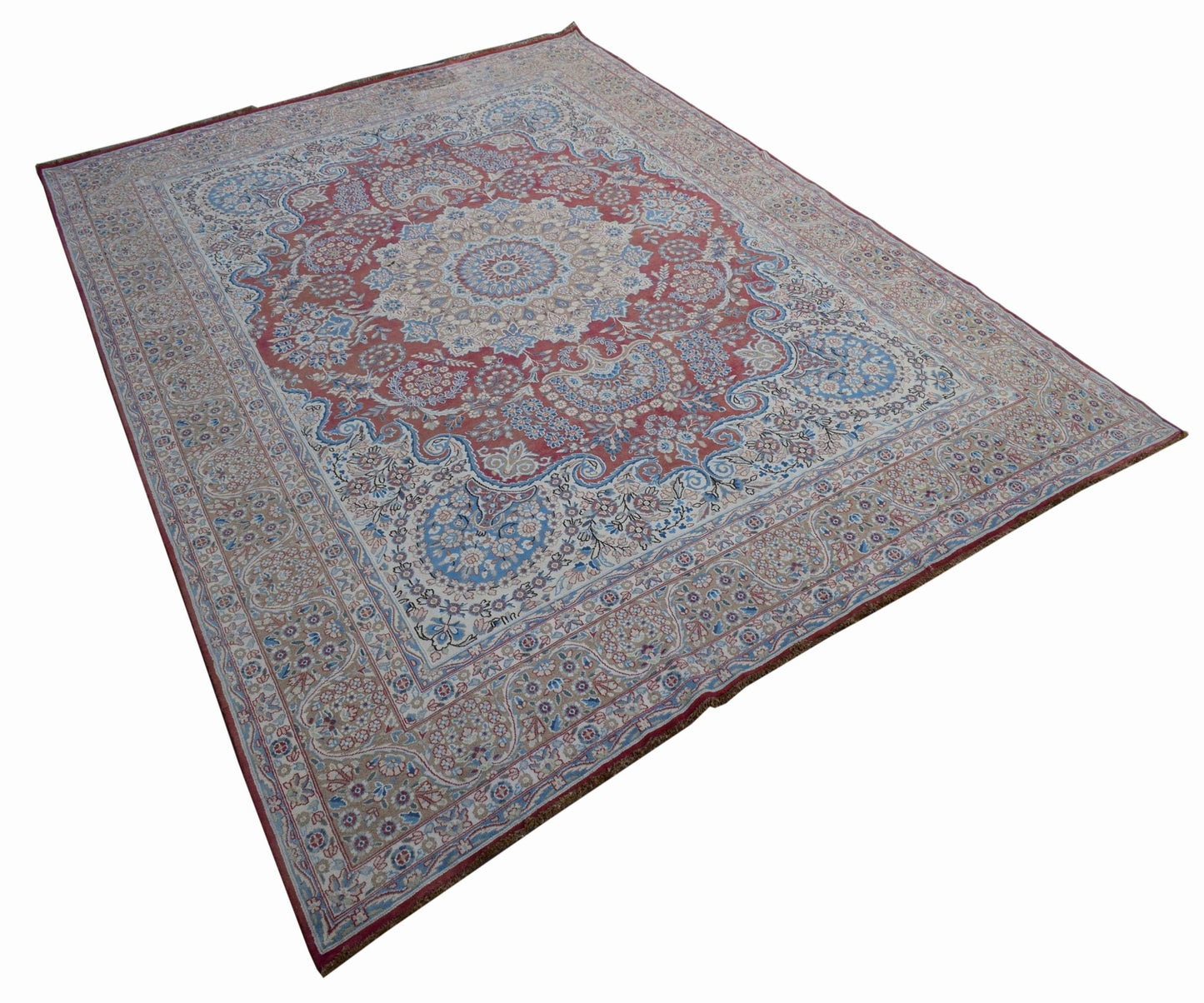 A vintage Persian Kerman rug featuring an intricate central medallion and floral patterns.