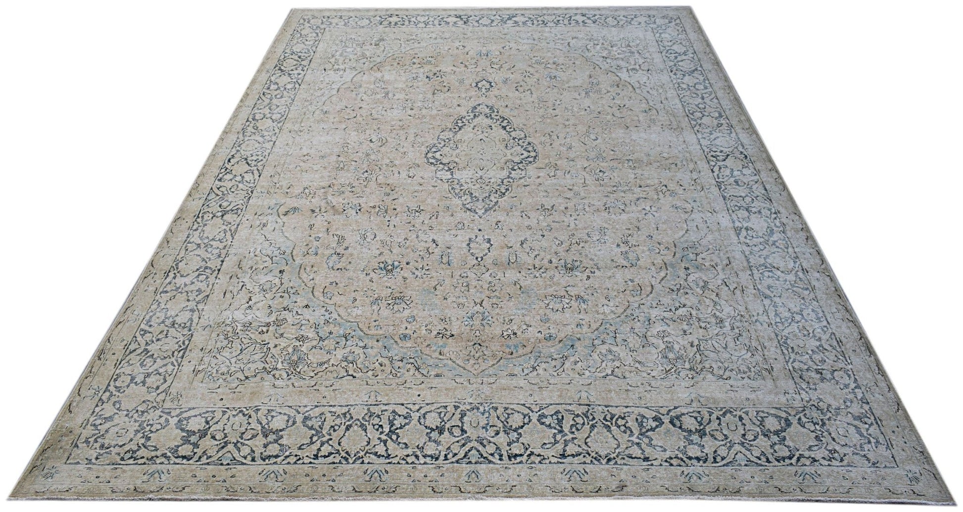 A vintage Persian Kerman rug featuring a central medallion and intricate floral patterns in blue.