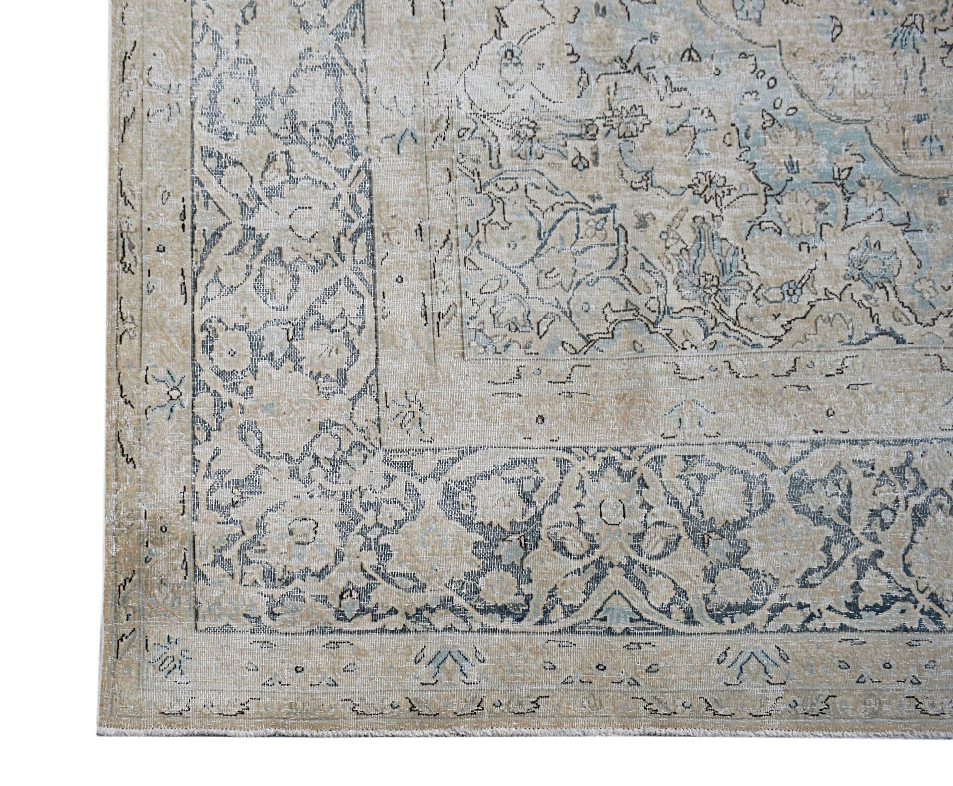A vintage Persian Kerman rug featuring intricate floral patterns in muted blue and beige tones.