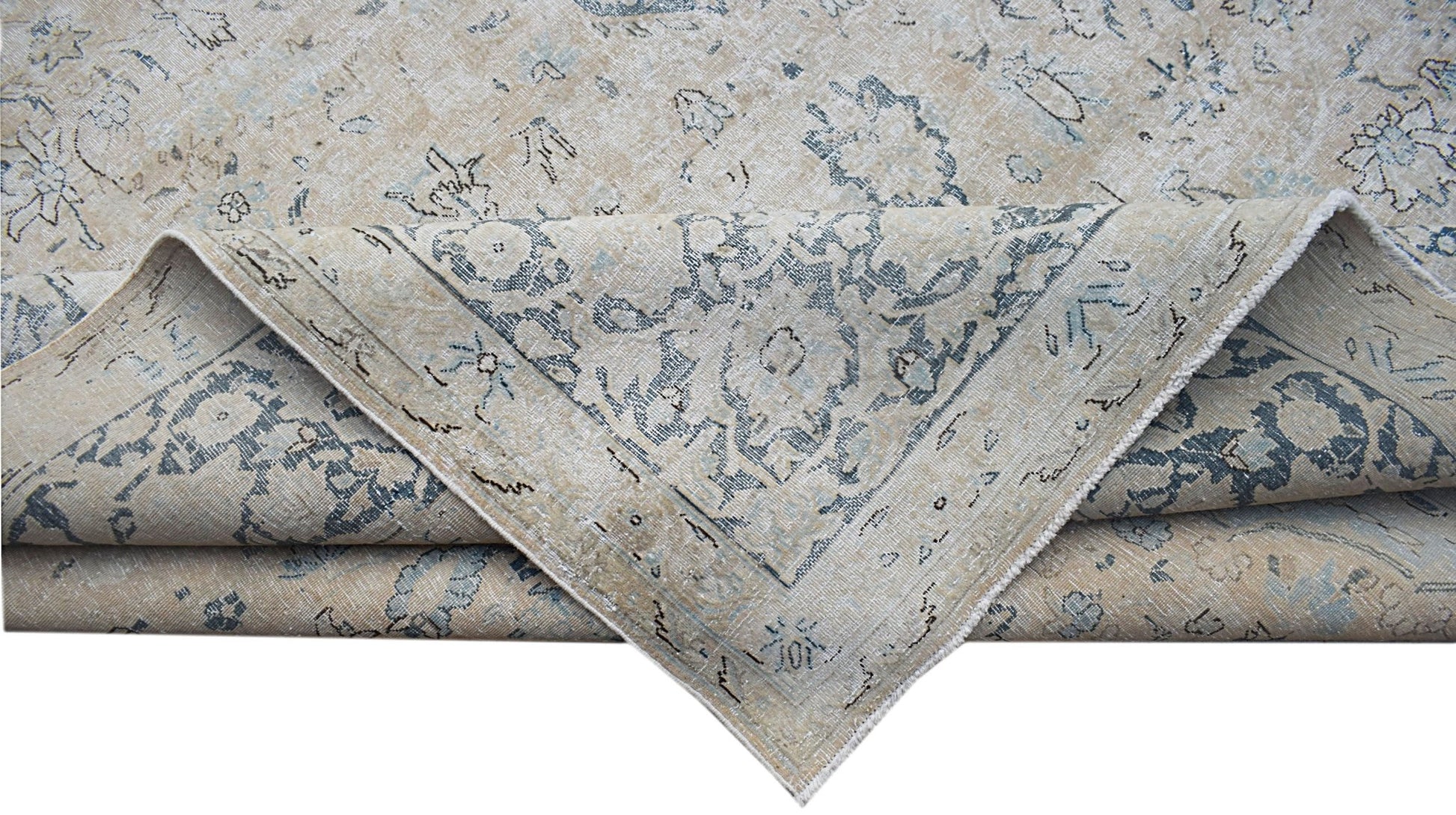 A vintage Persian Kerman rug featuring a faded floral medallion pattern in blue and beige tones.