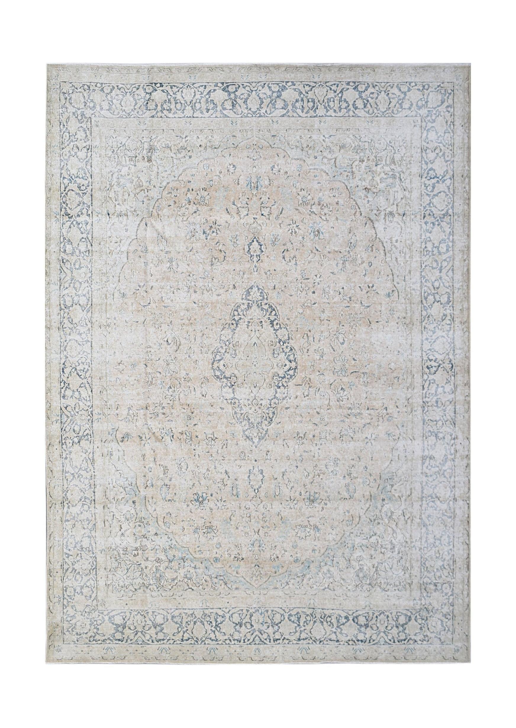 A vintage Persian Kerman rug featuring a central medallion and intricate floral patterns in blue.