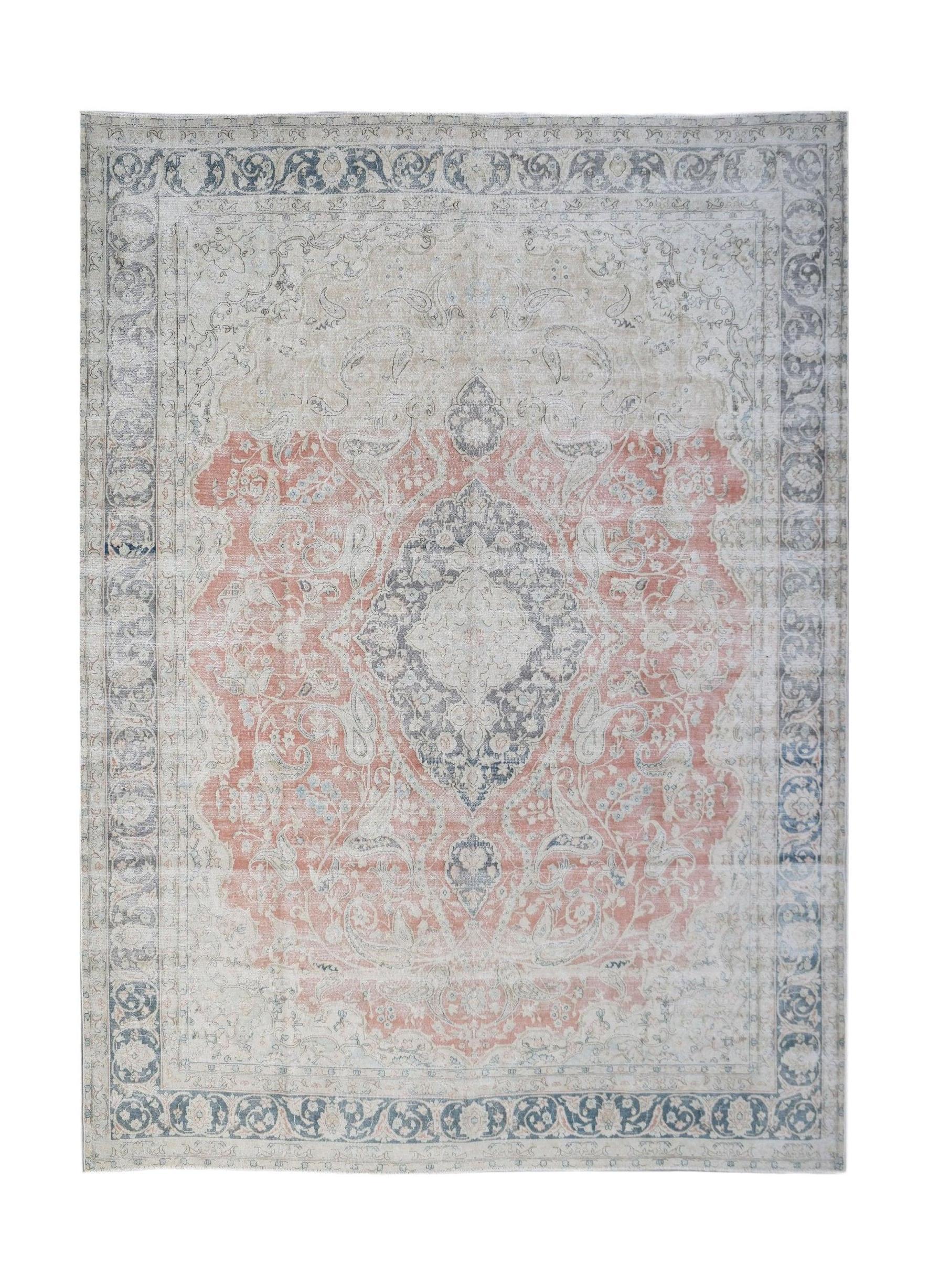 A vintage Persian Kerman rug featuring a central medallion and floral motifs in muted tones.
