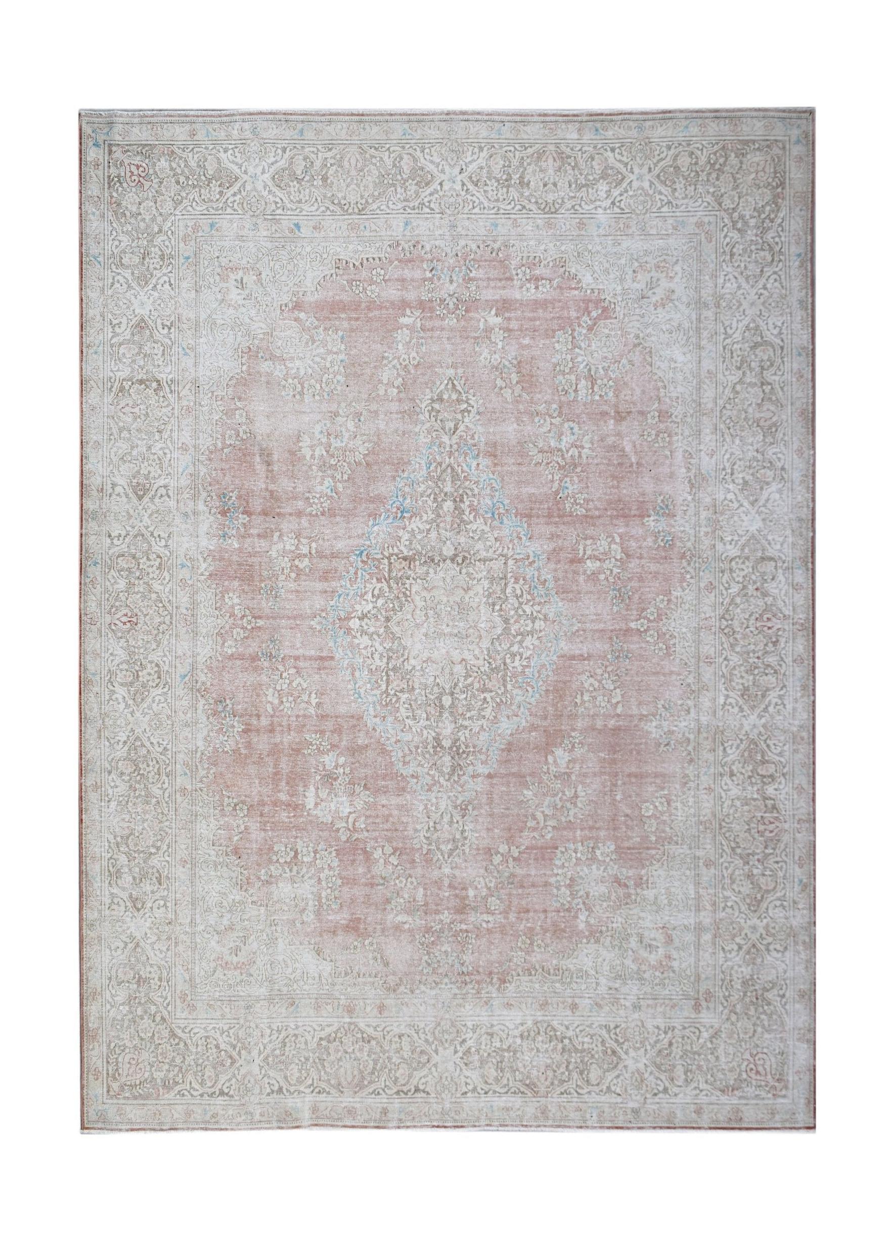 A vintage Persian Kerman rug featuring a central medallion and intricate floral patterns in pink.