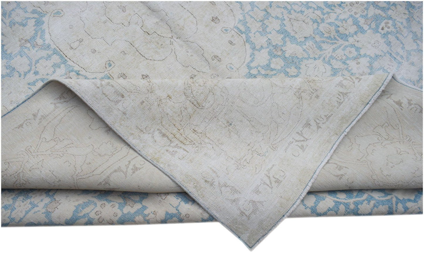 A vintage Persian Kerman rug featuring a light blue and beige floral pattern with a central design.