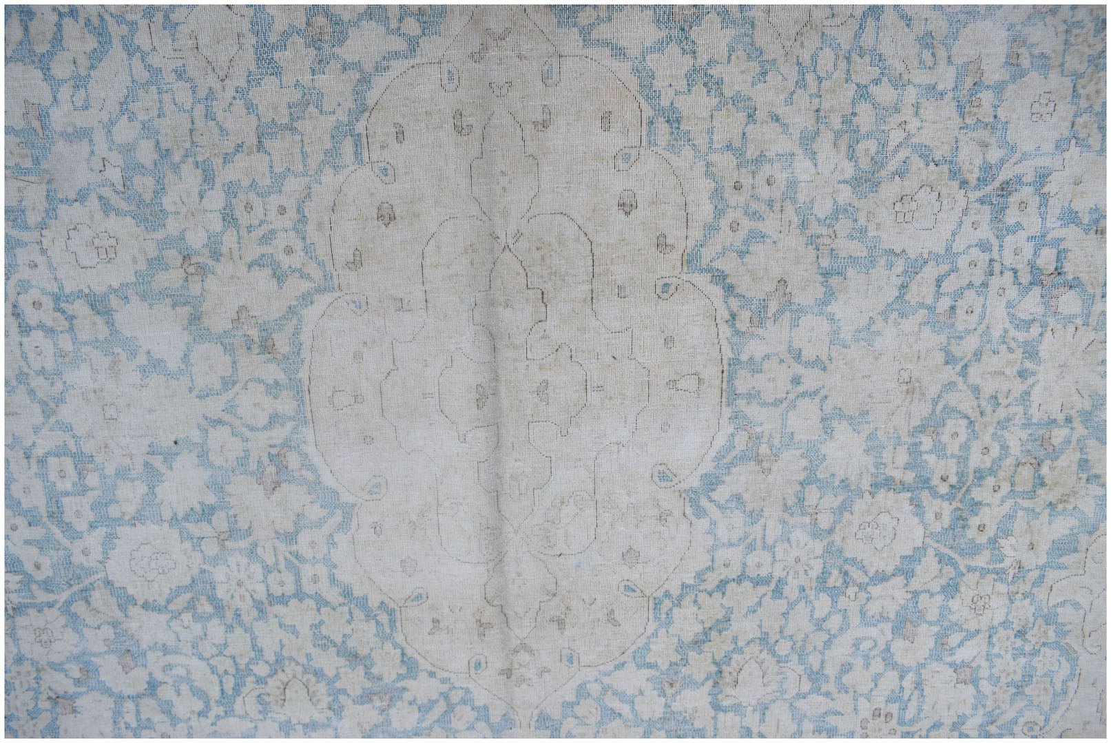 A vintage Persian Kerman rug featuring a central medallion surrounded by intricate floral patterns.