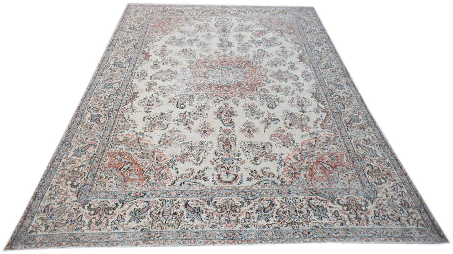 A vintage Persian Kerman rug featuring a central medallion and intricate floral patterns.