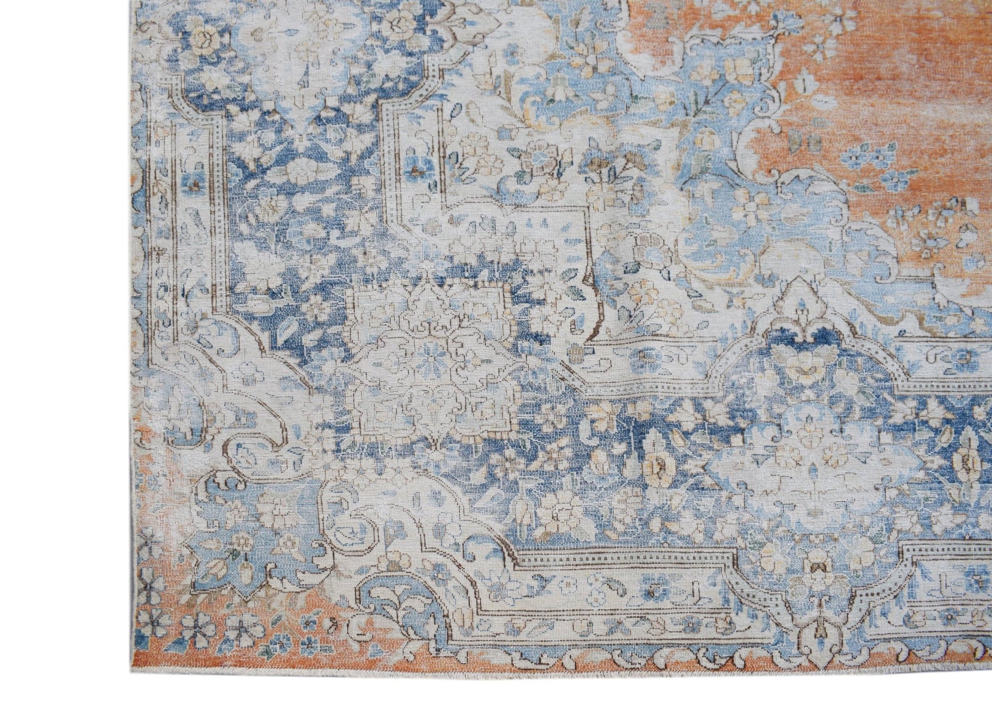 A vintage Persian Kerman rug featuring an intricate floral pattern in blue, cream, and orange.