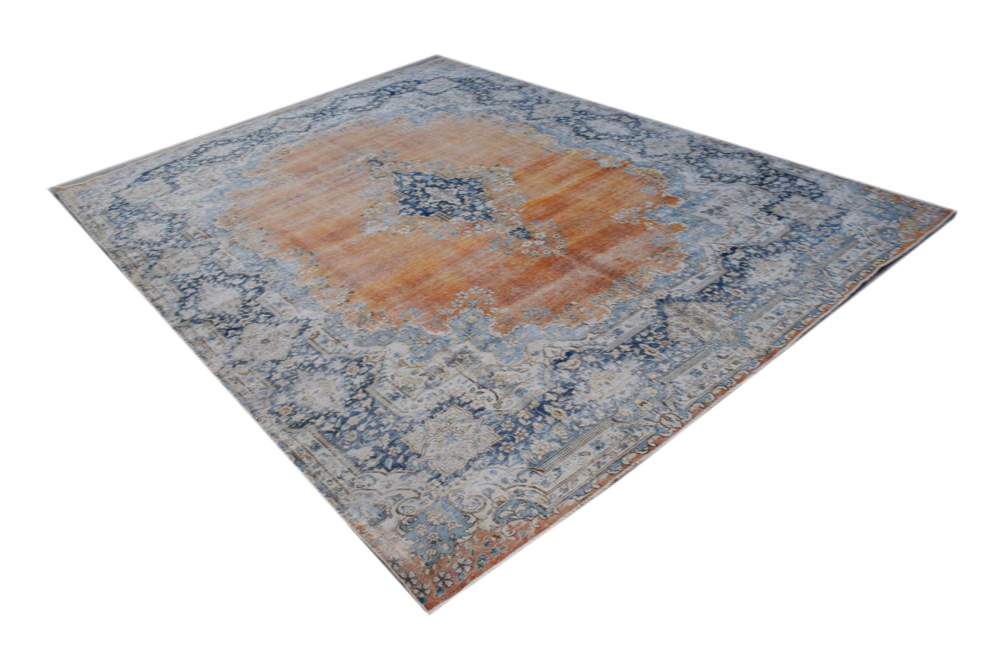 A vintage Persian Kerman rug featuring a central medallion with intricate blue and orange patterns.