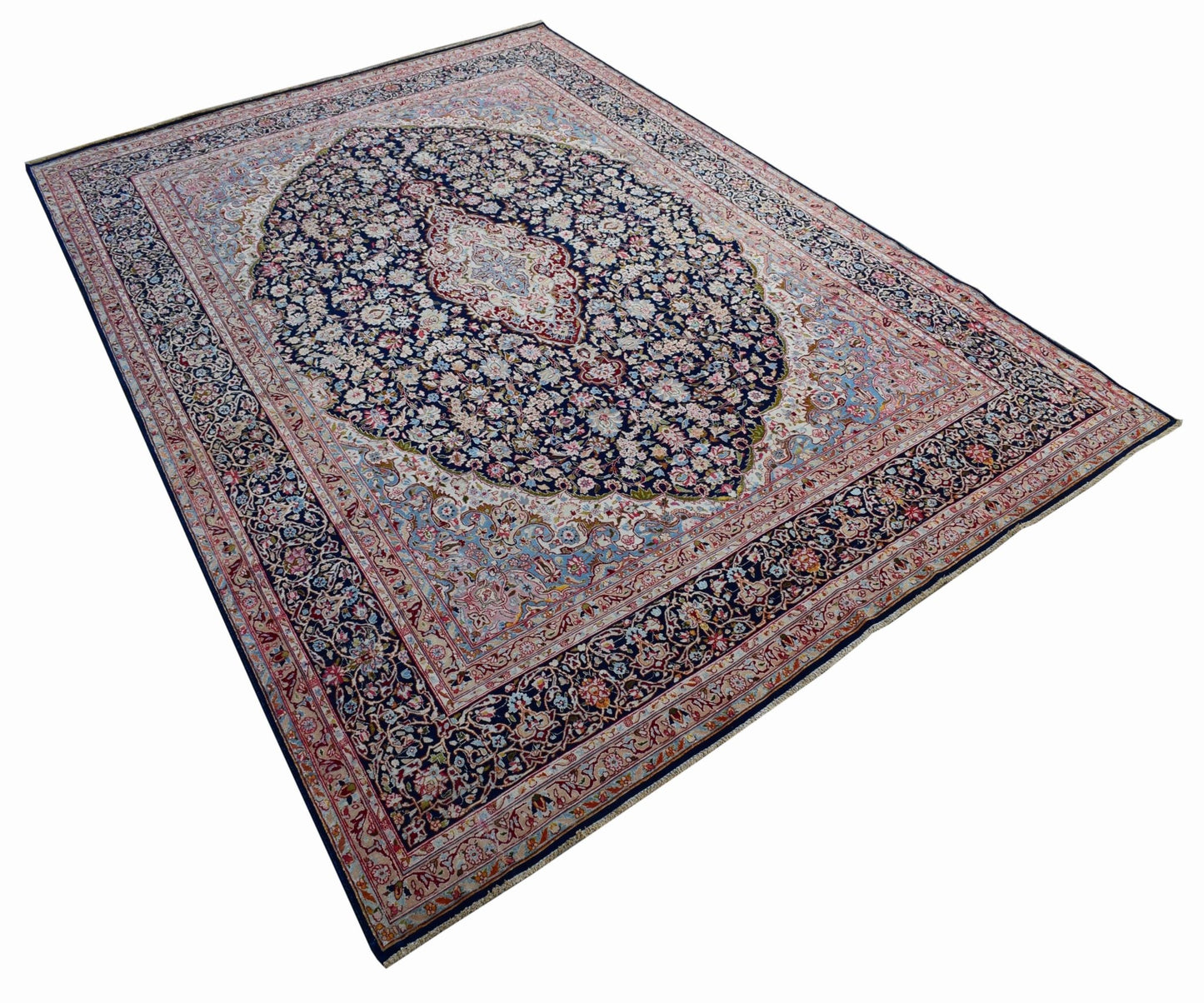 A vintage Persian Kerman rug featuring an intricate floral medallion on a dark blue field.