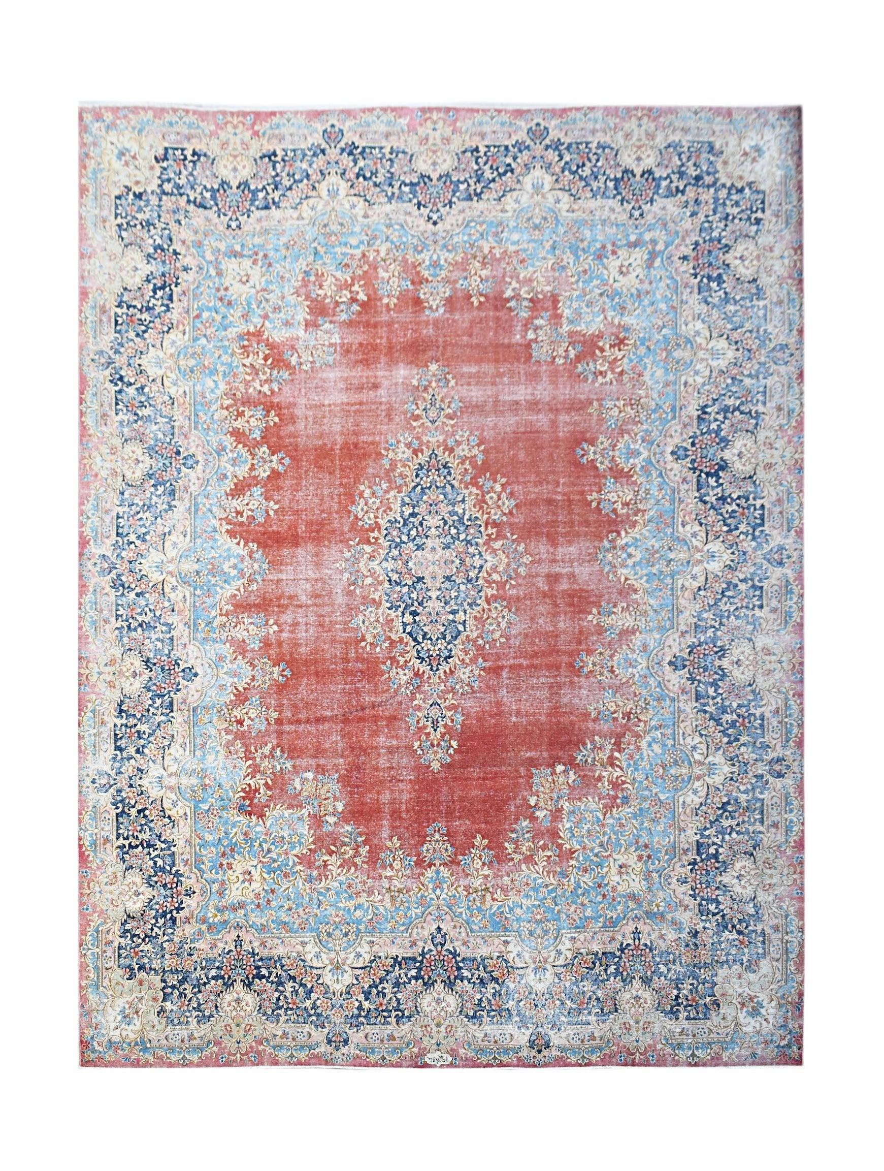 A vintage Persian Kerman rug featuring a central floral medallion on a red field with blue borders.