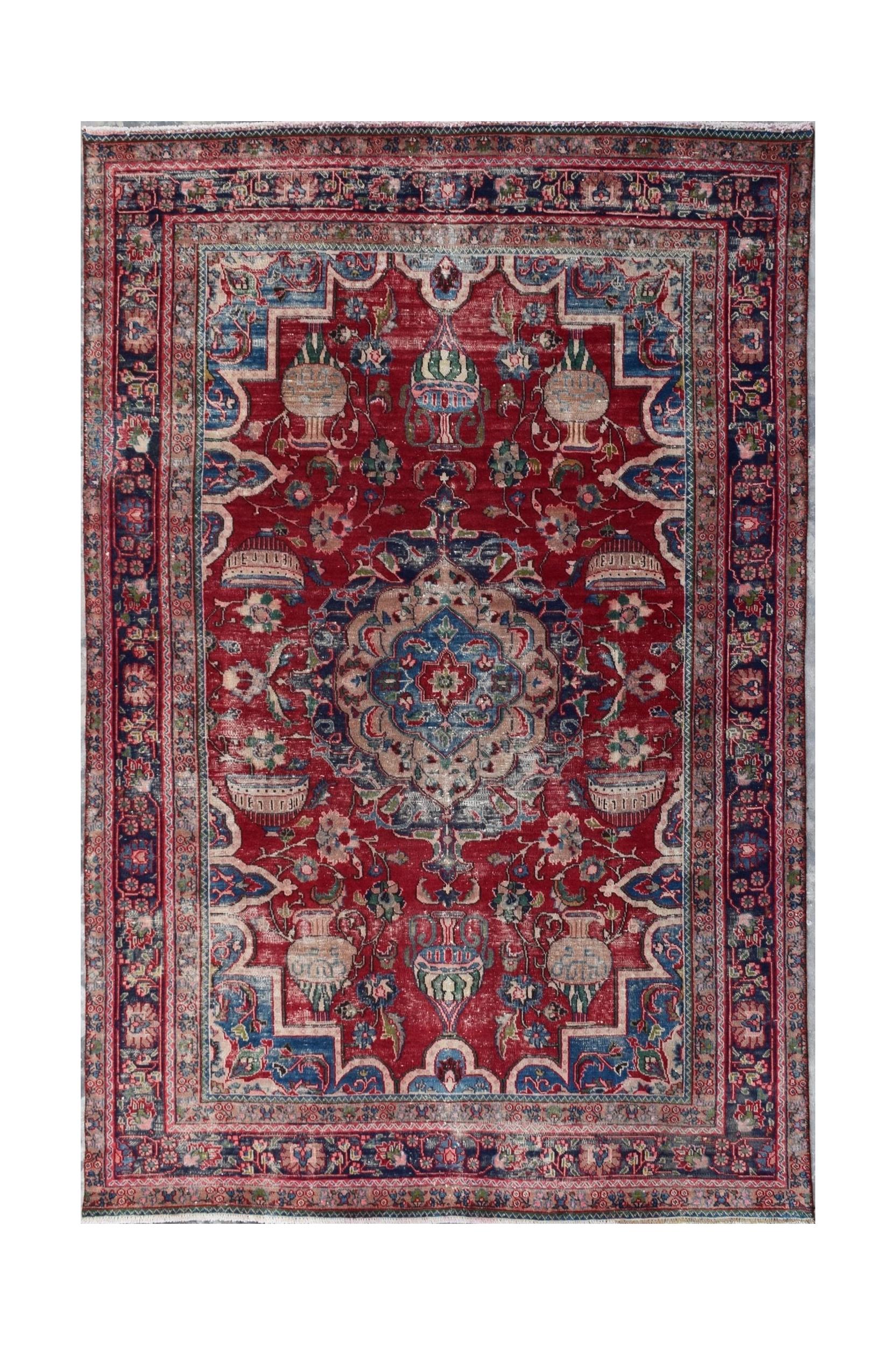 A vintage Persian Tabriz rug featuring a central medallion and intricate floral vase motifs.