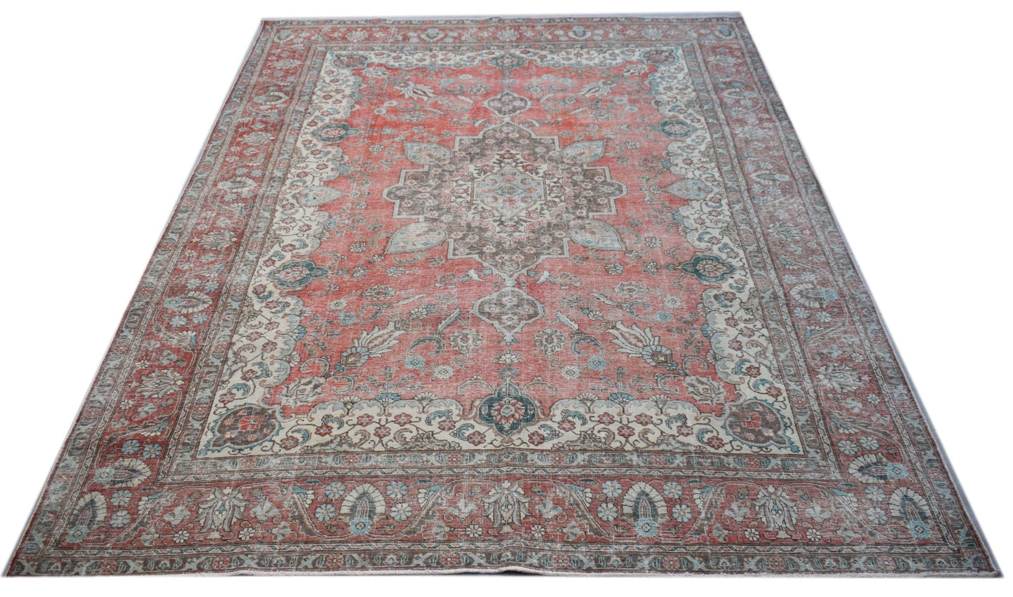 A vintage handwoven Persian Tabriz rug featuring a central medallion and intricate floral patterns.