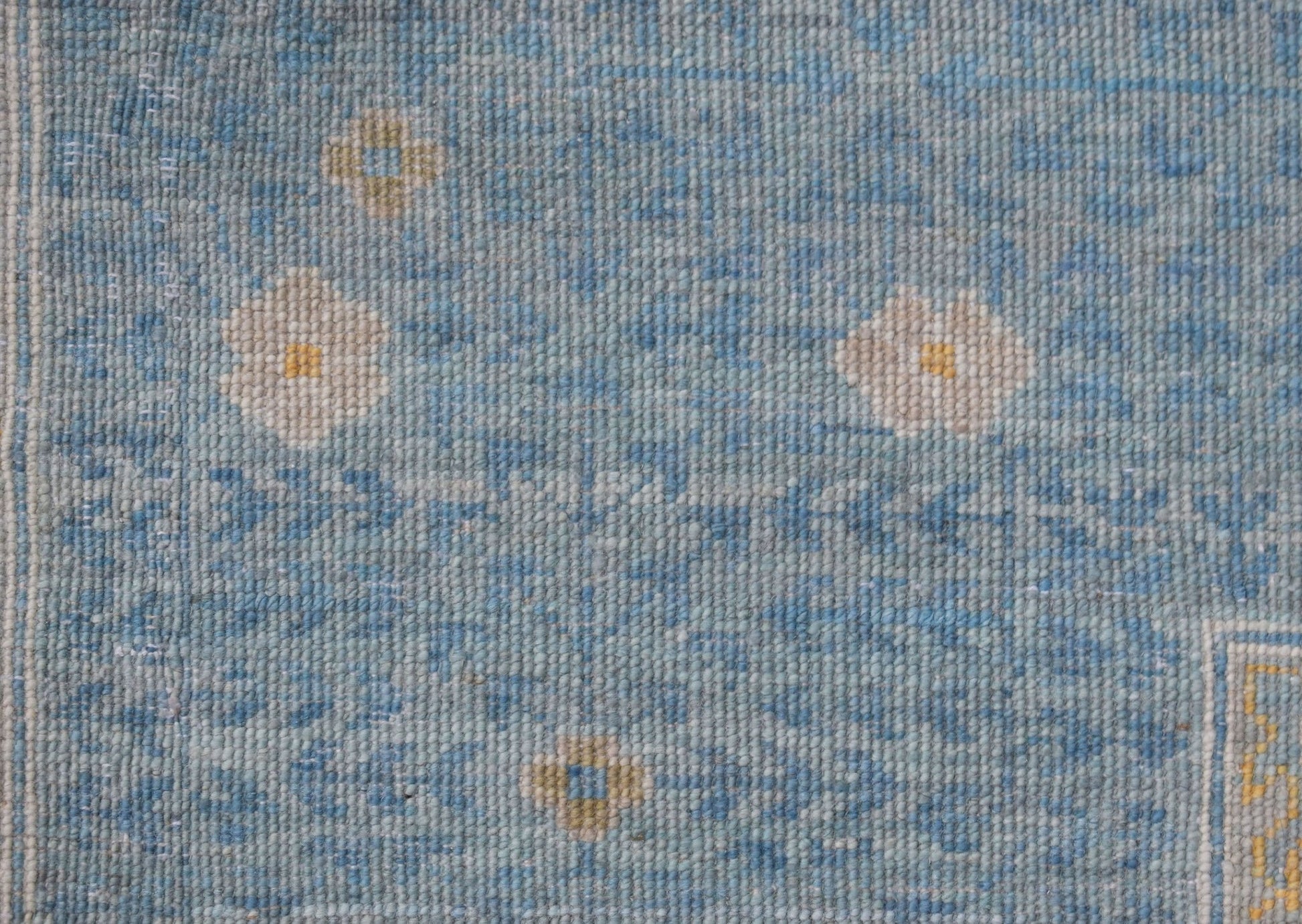 A handwoven Afghan Balkh rug featuring a light blue field with small floral motifs.