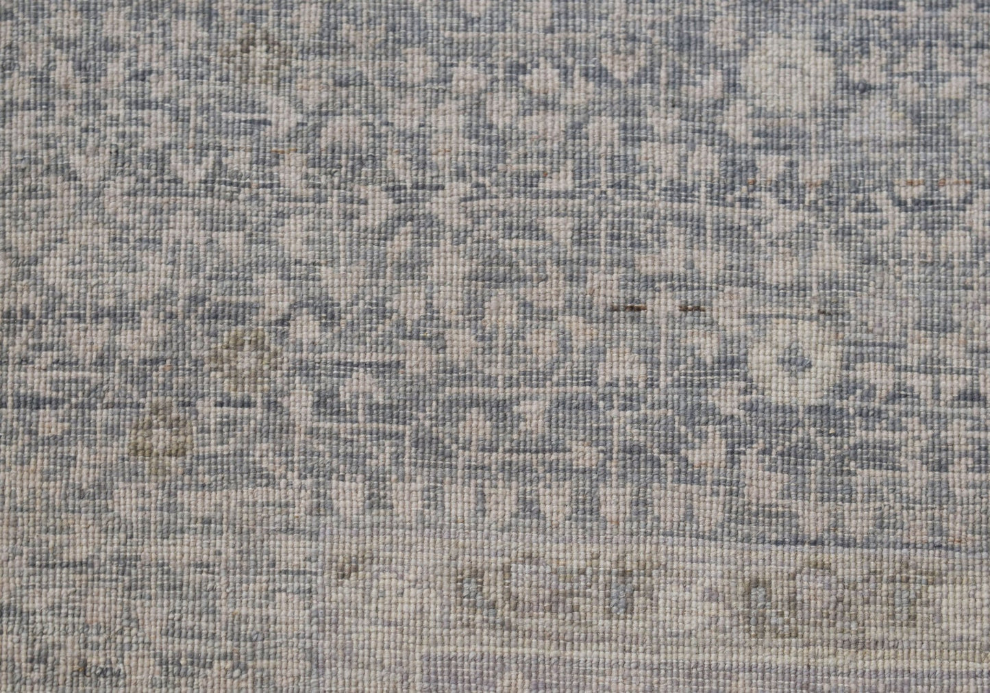A close-up of a handwoven Afghan rug featuring a detailed blue and cream Mamluk pattern.