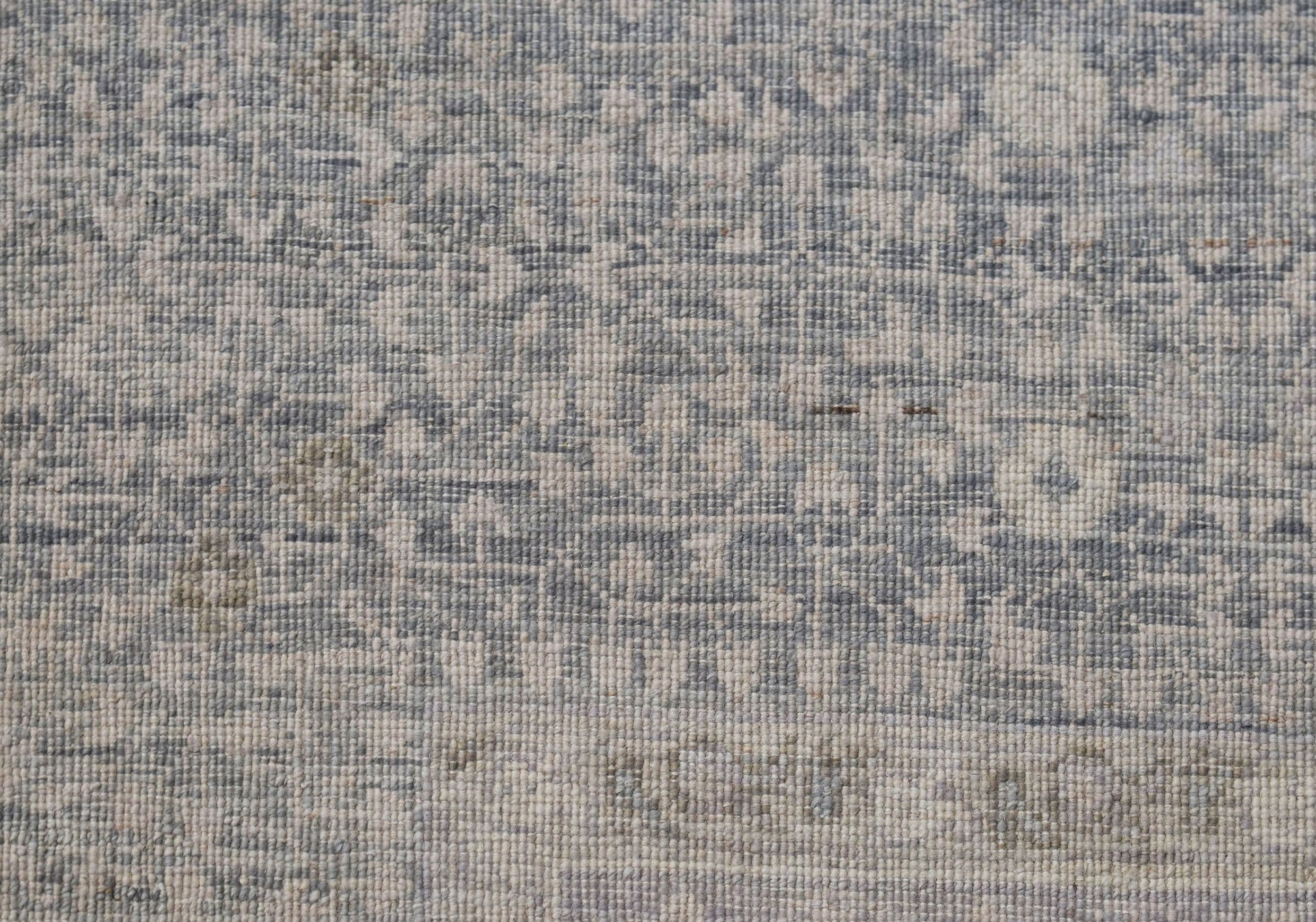 A close-up of a handwoven Afghan rug featuring a detailed blue and cream Mamluk pattern.