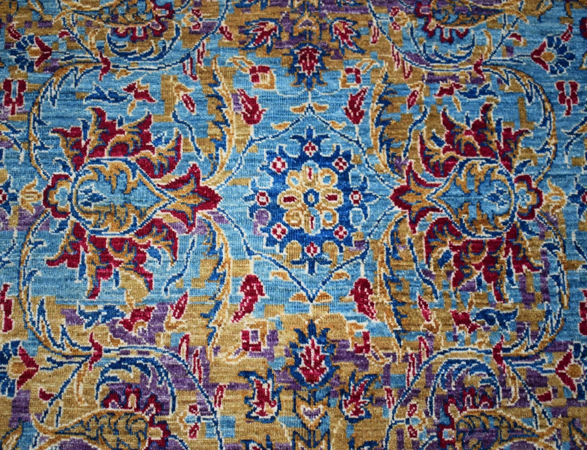 Handwoven Afghan Chobi rug featuring a traditional floral pattern in blue, gold, and red tones.