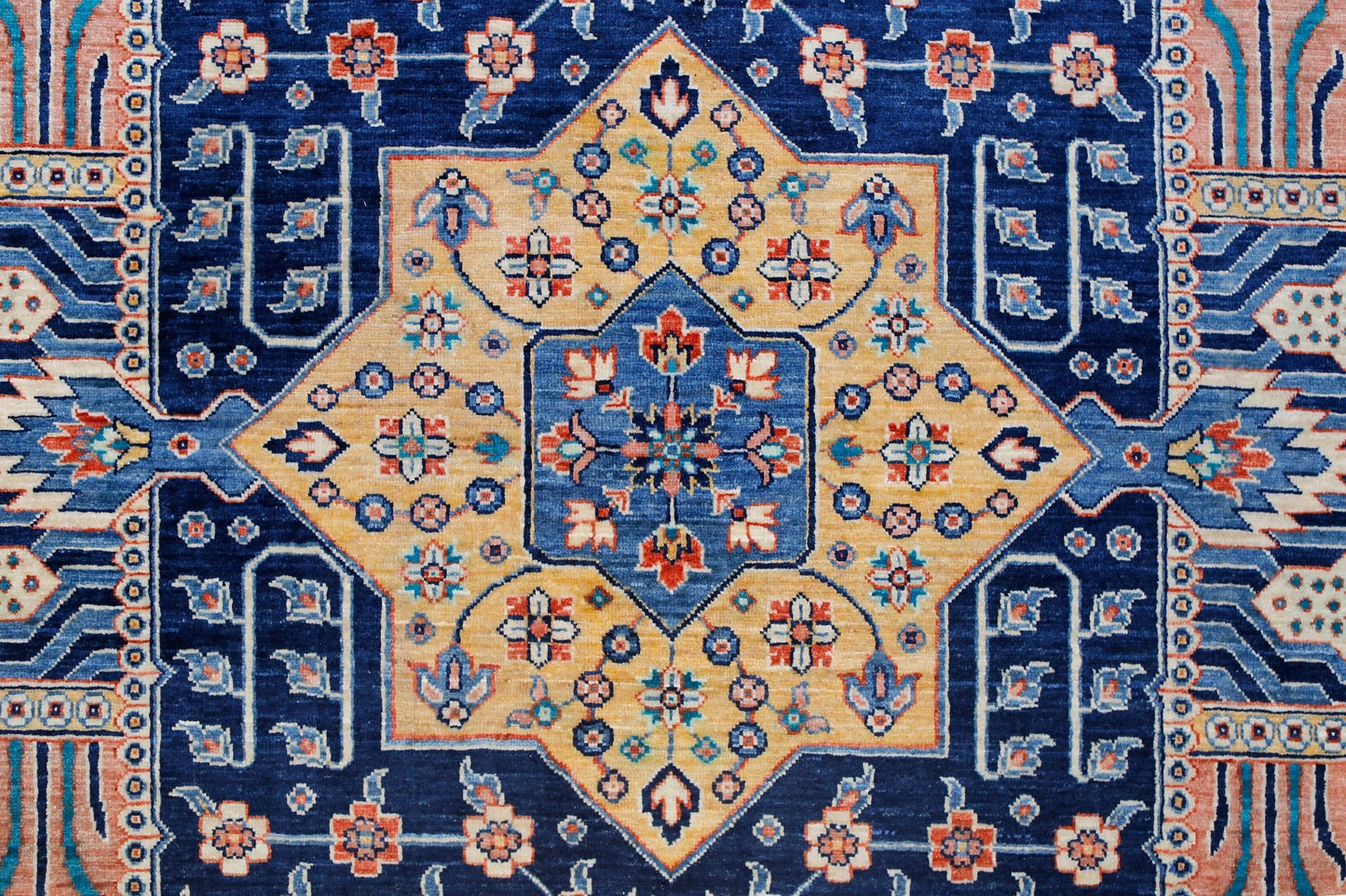 A handwoven Afghan Balkh rug featuring a central geometric star pattern in blue and gold tones.