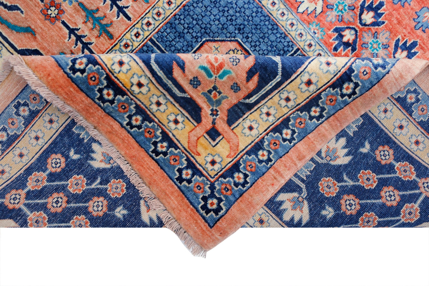 A handwoven Afghan Balkh rug featuring a blue field with floral patterns and a folded corner.