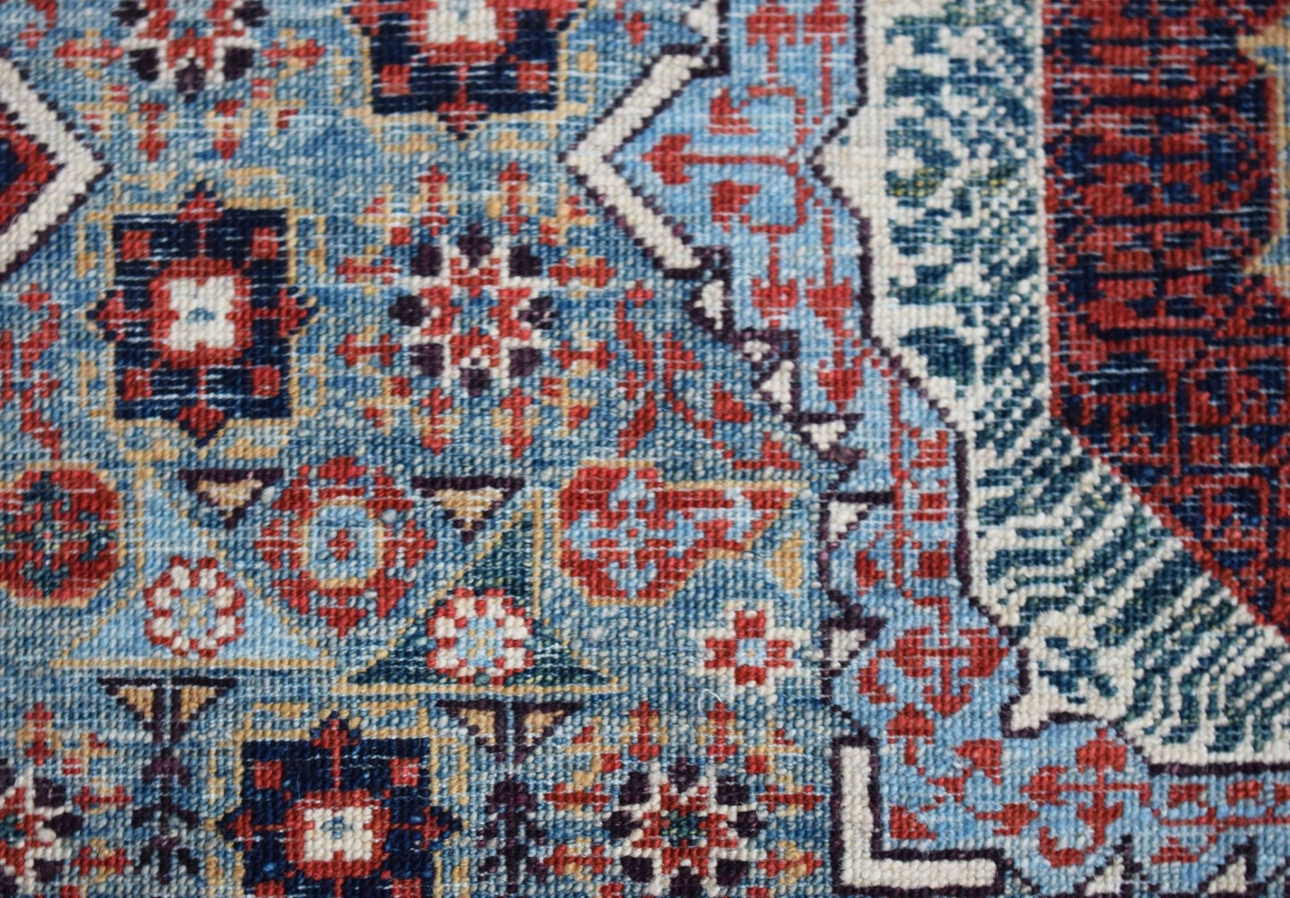 A handmade Afghan Balkh rug featuring a detailed blue, red, and cream Mamluk geometric pattern.