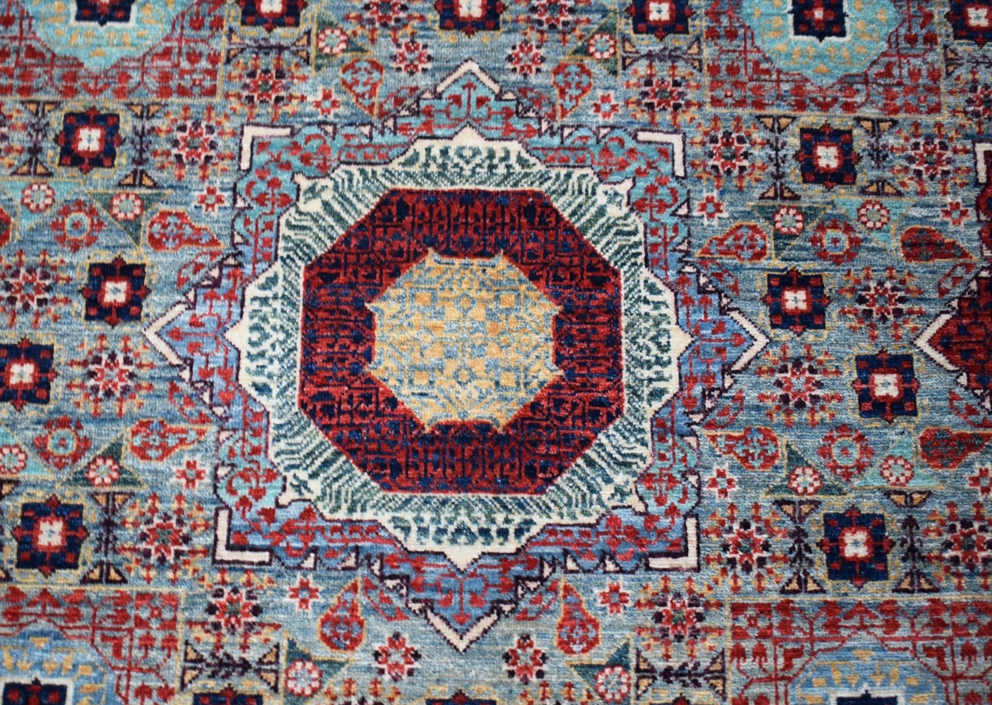 Handwoven Afghan Balkh rug featuring a detailed Mamluk medallion pattern in blue, red, and gold.